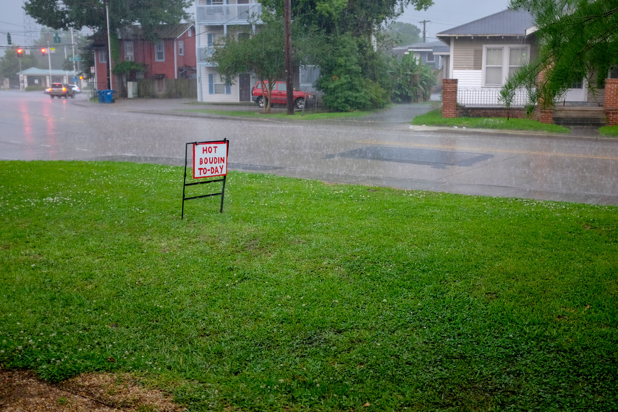 Handpainted yard sign that says "Hot Boudin To-Day" it is also raining really hard