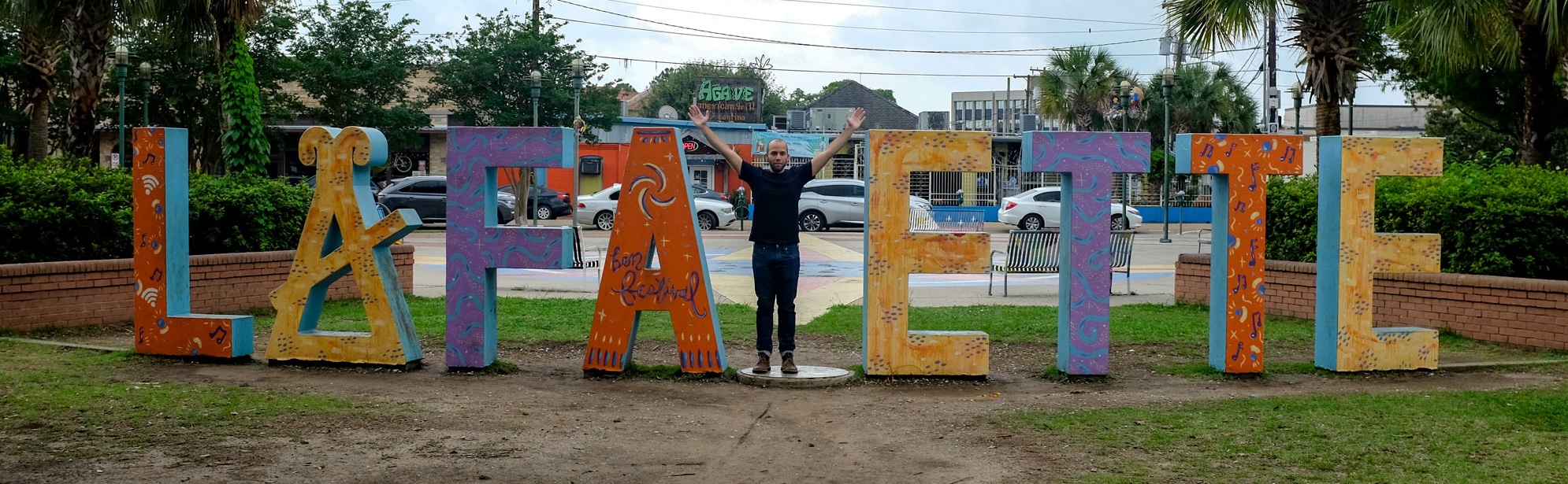Michael standing in a sign that says "Lafayette" except he is standing where the Y should be with his arms outstretched to form the letter Y
