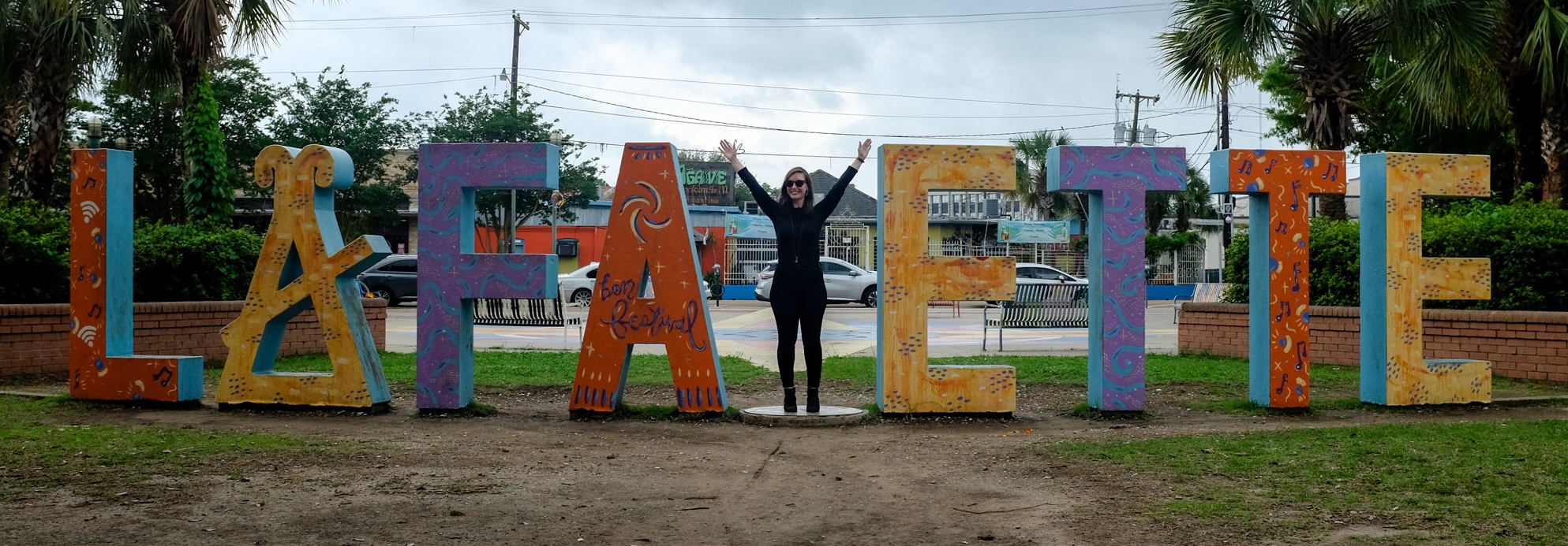 Alyssa standing in a sign that says "Lafayette" except she is standing where the Y should be with her arms outstretched to form the letter Y