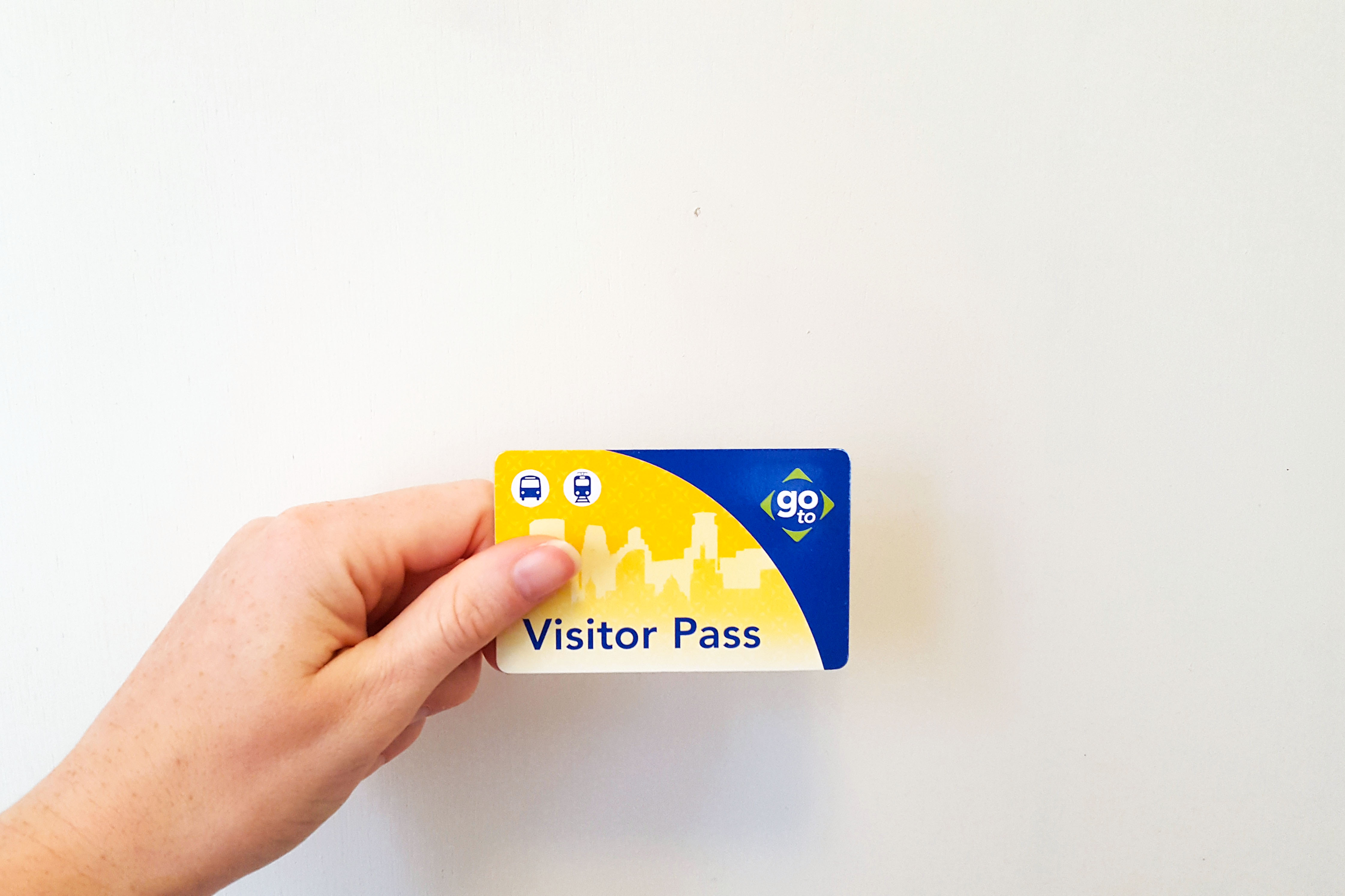 Alyssa holding a visitor pass transit card