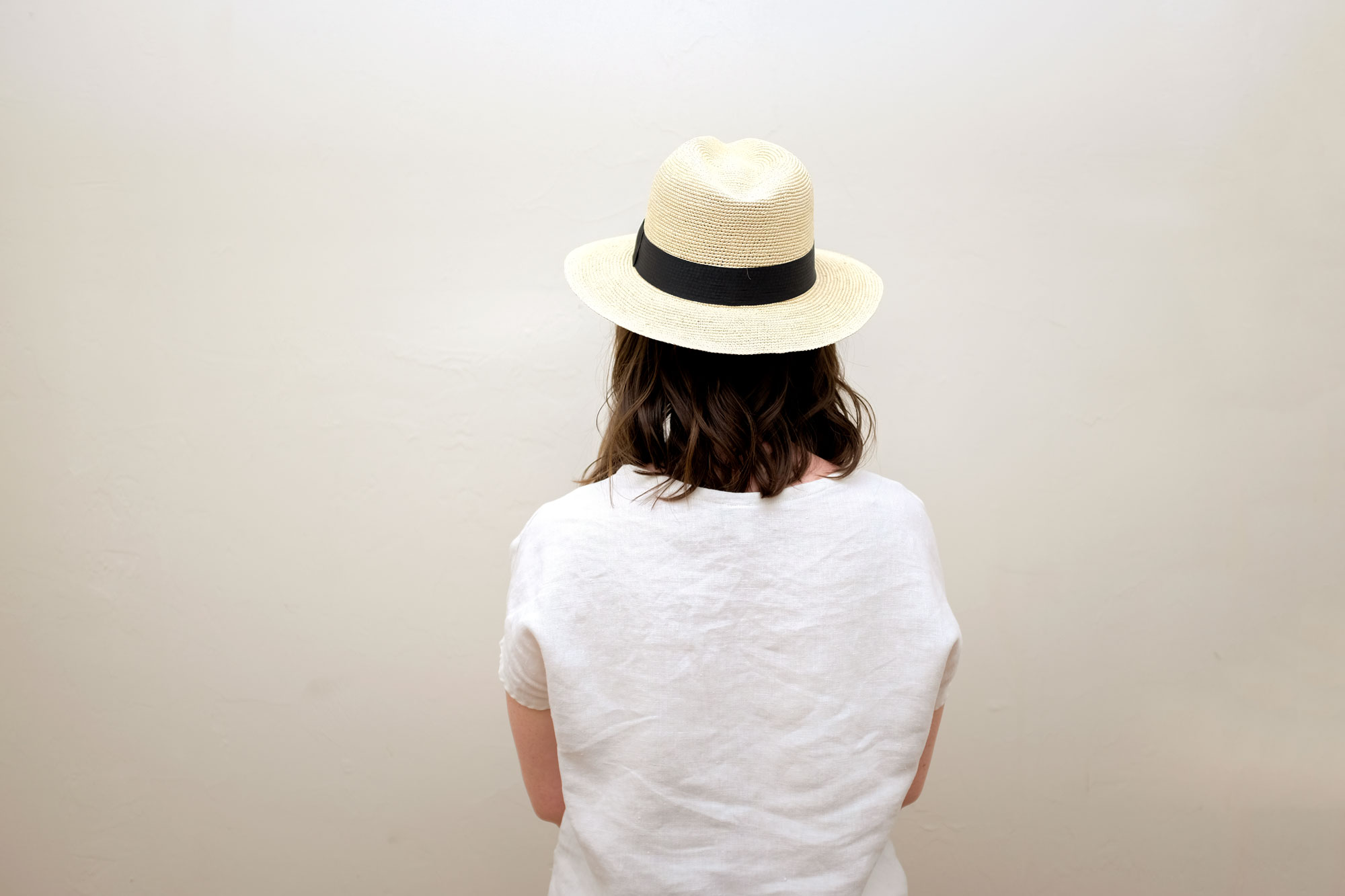 Krystal wearing the Cuyana hat, facing away from the camera. 