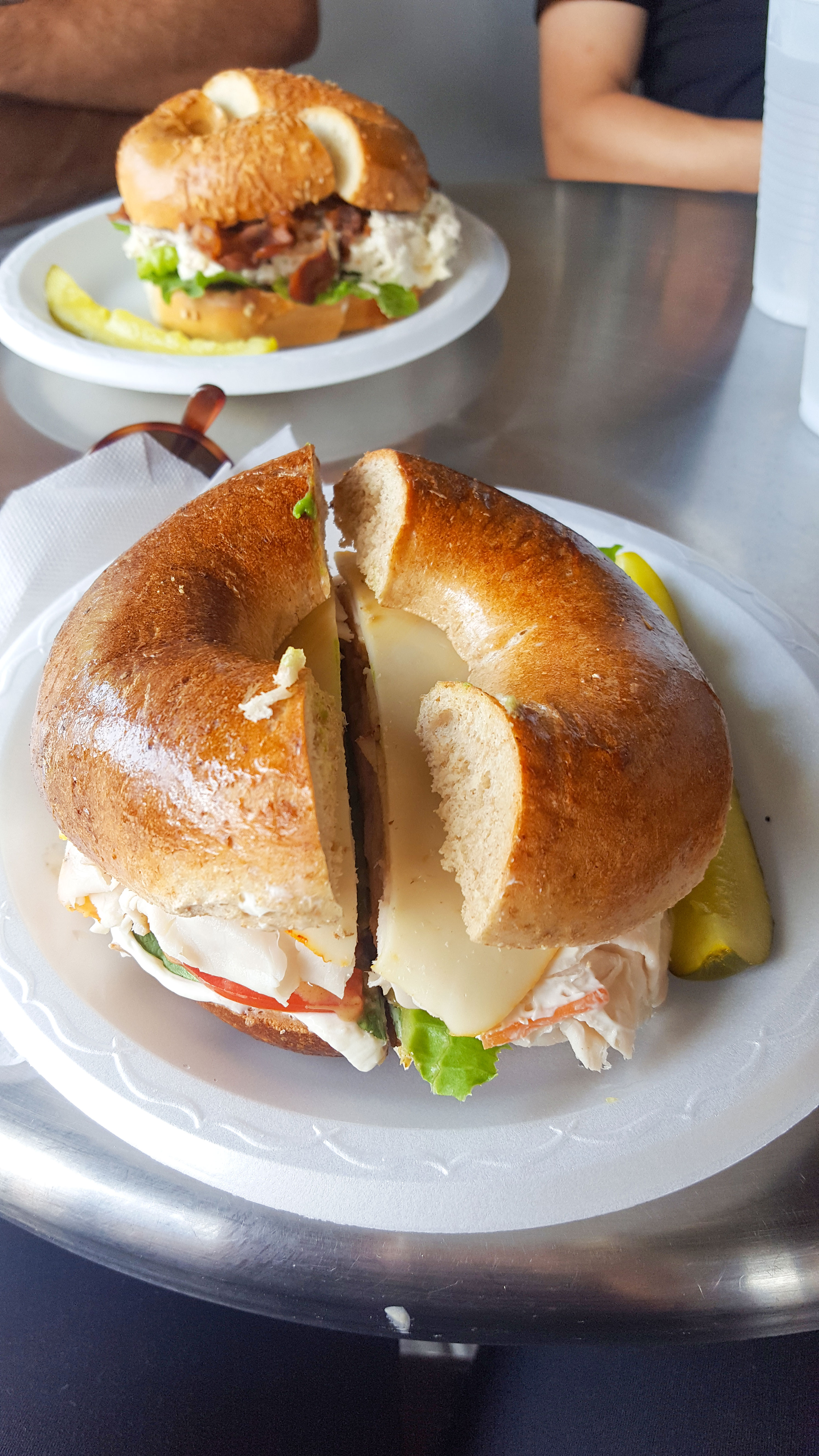 Two plates with bagel sandwiches