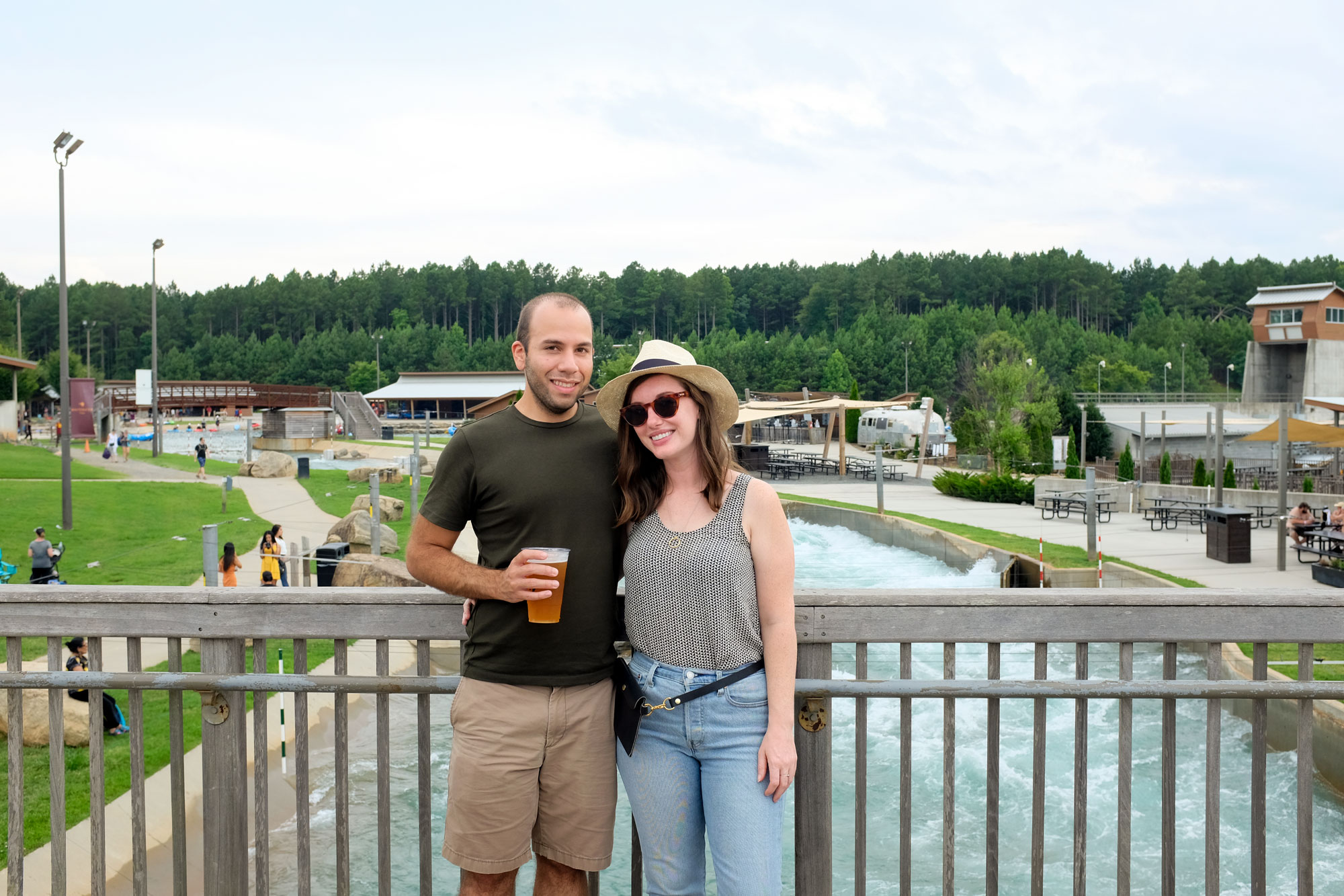 Krystal and Michael standing on a bridge over the National Whitewater Center's whitewater rafting course