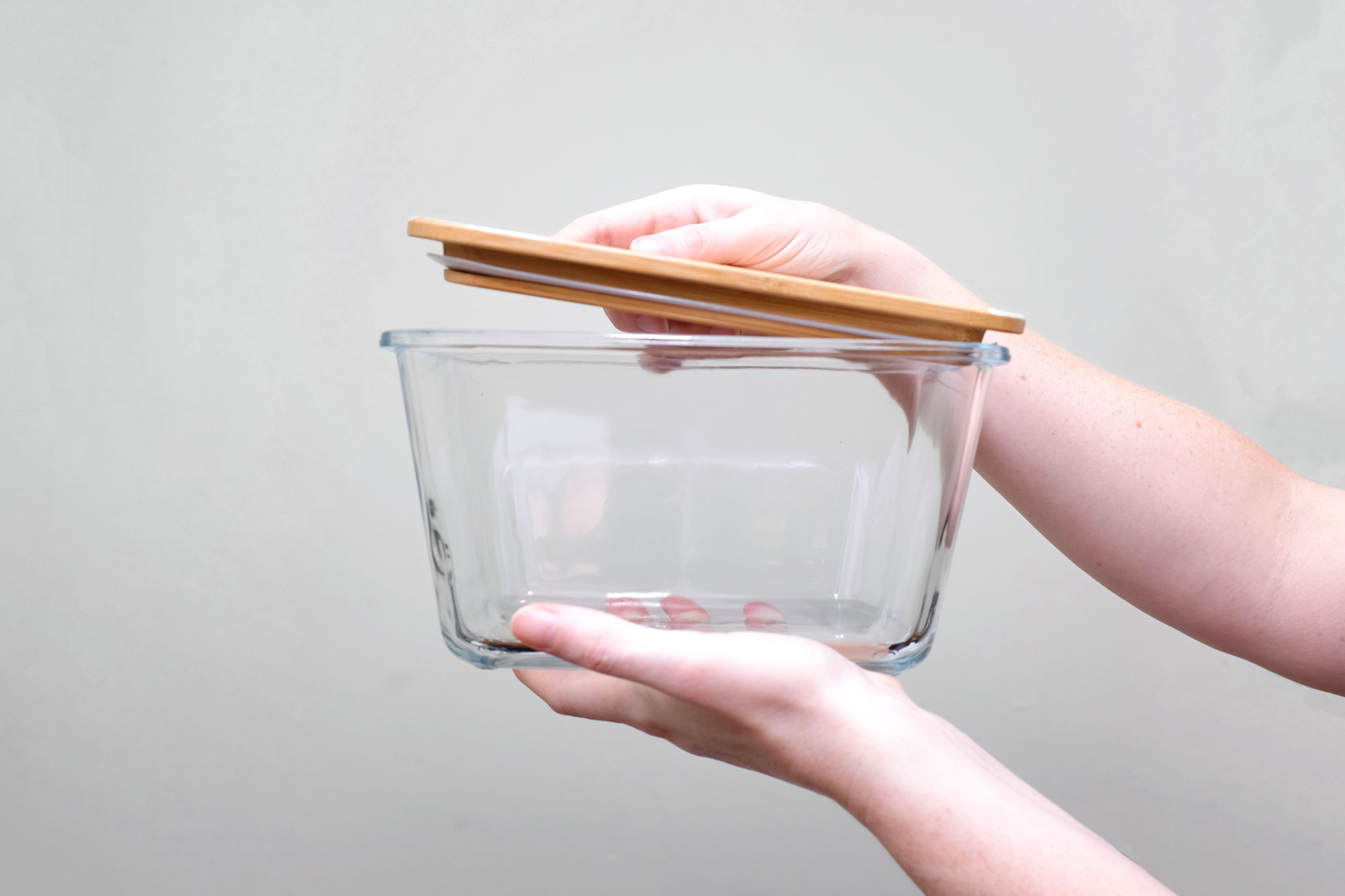 Alyssa opening a glass container with a wooden lid