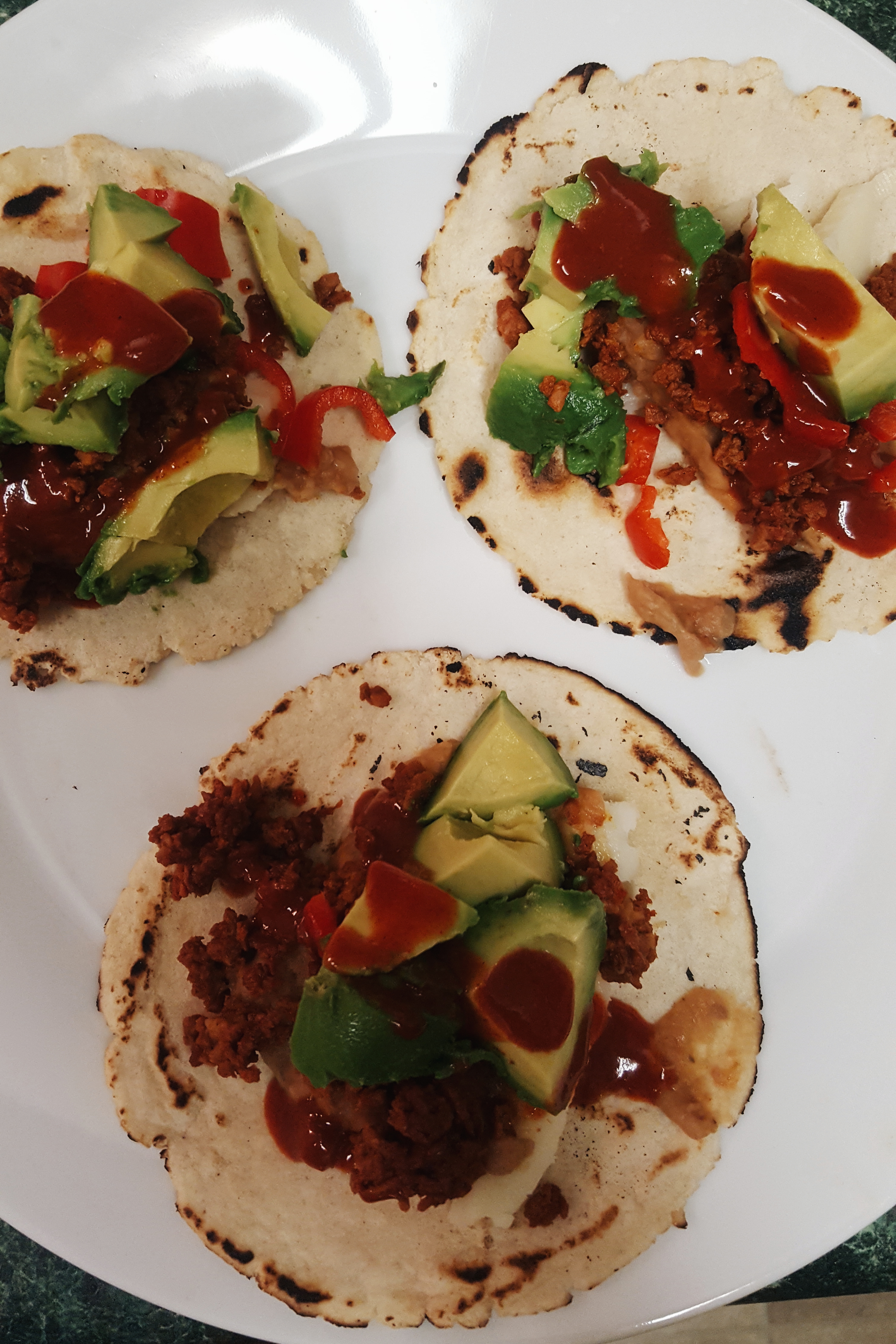 A plate of bean + soy-chorizo tacos on homemade corn tortillas