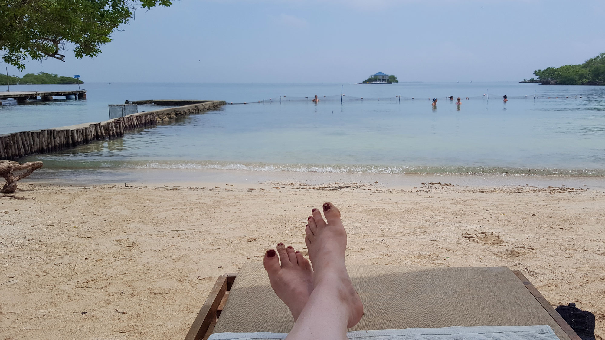 Krystal's feet are in the foreground on the beach chair, and the water is in the background