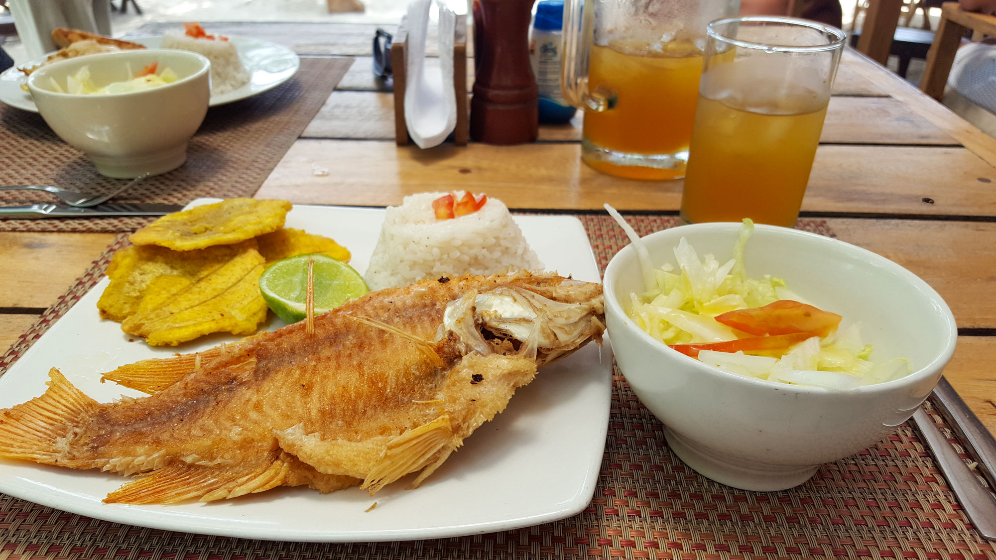 Krystal's meal: salad, fish, plantains, and aguapanela
