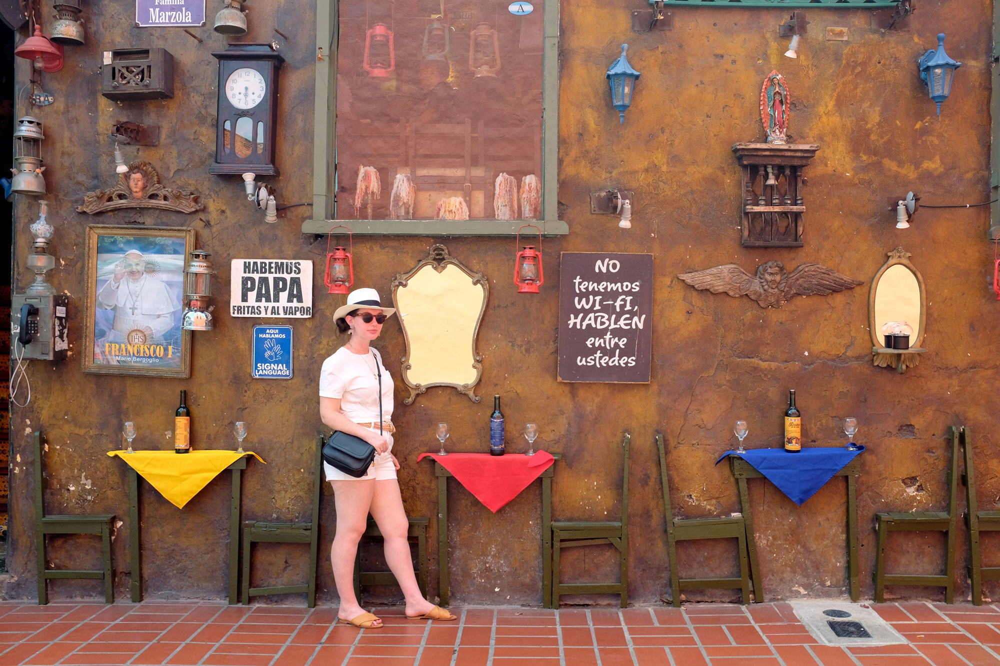 Alyssa standing in front of a wall with inlaid chairs and tables