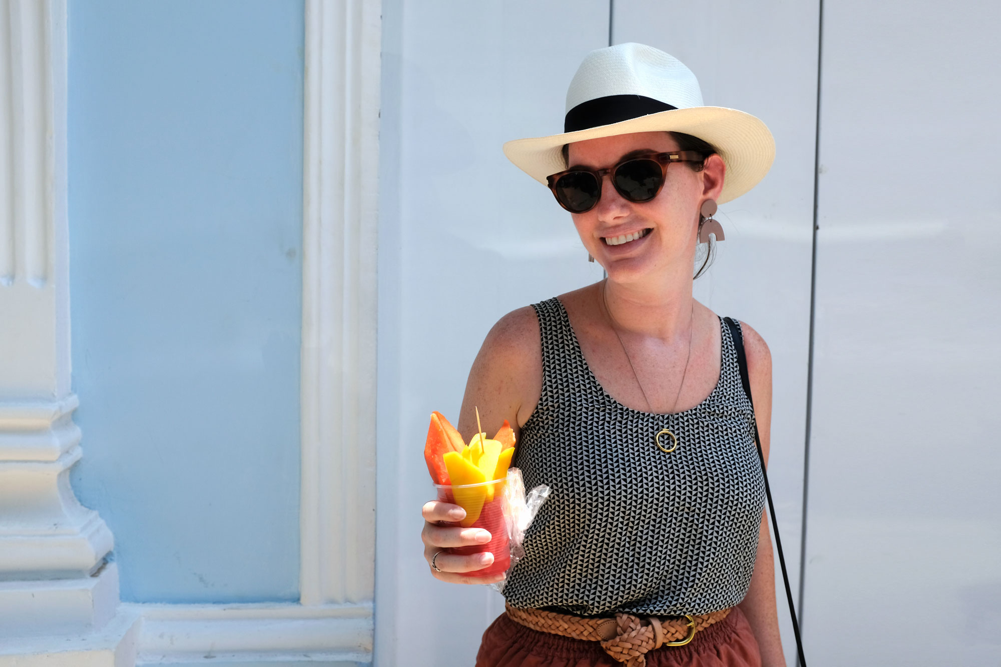 Krystal holding a cup of mango, papaya, and watermelon