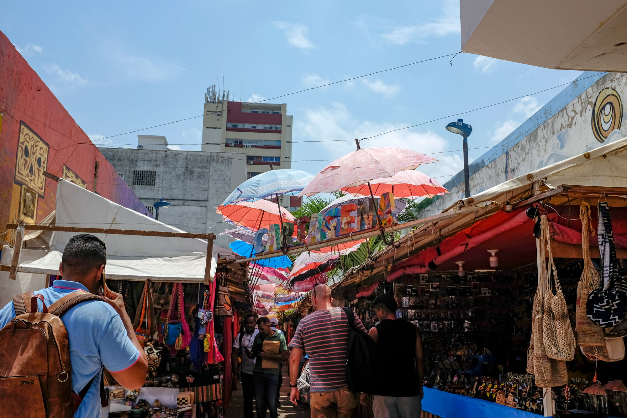 Street market in Cartagena. There are lots of vendors and umbrellas covering the walkway