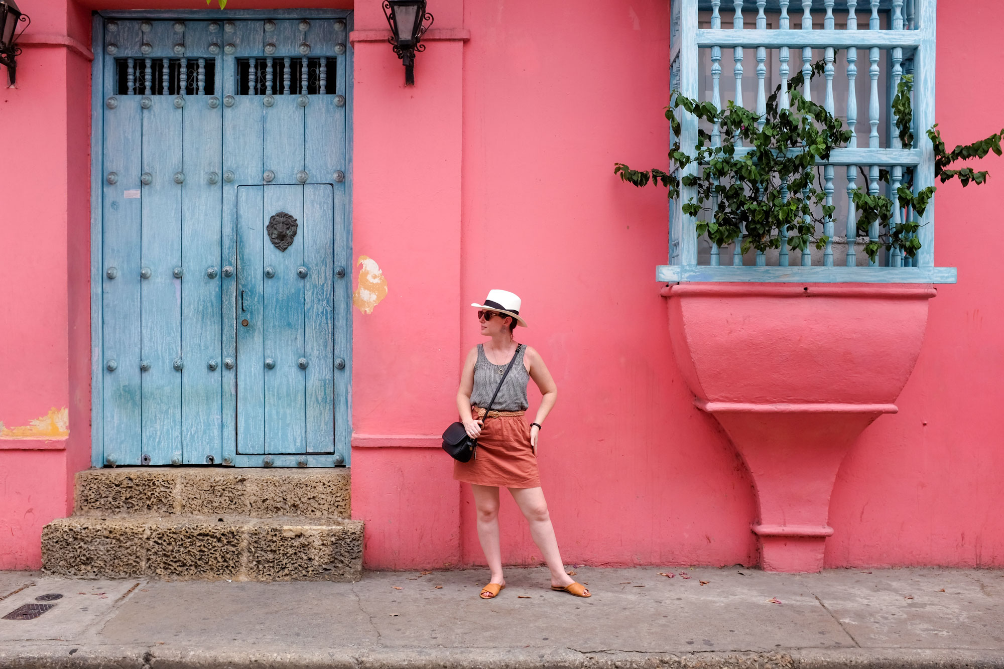 Alyssa standing in front of a bright pink wall in Cartagena