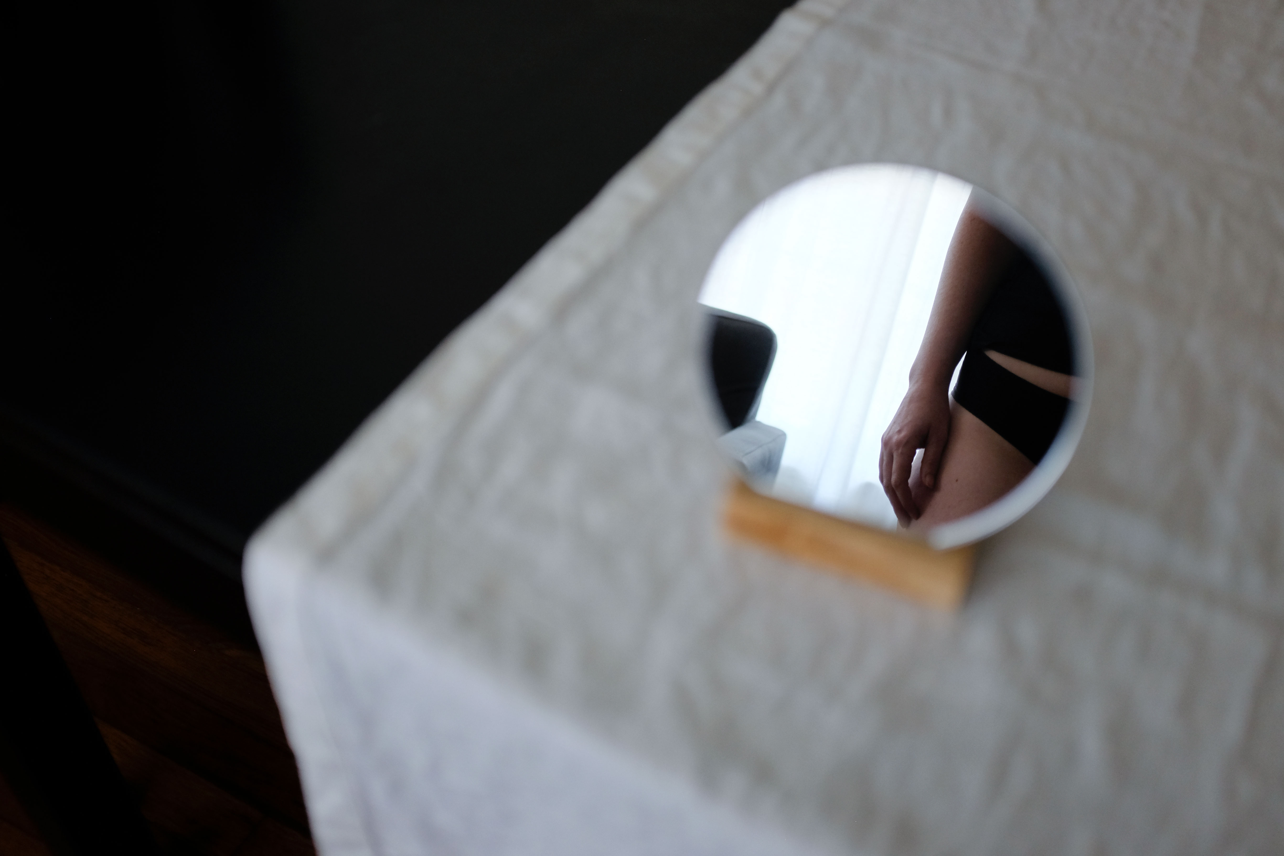 Alyssa standing in front of a small mirror. You can see just part of her side, including her tee and undies (shh!)