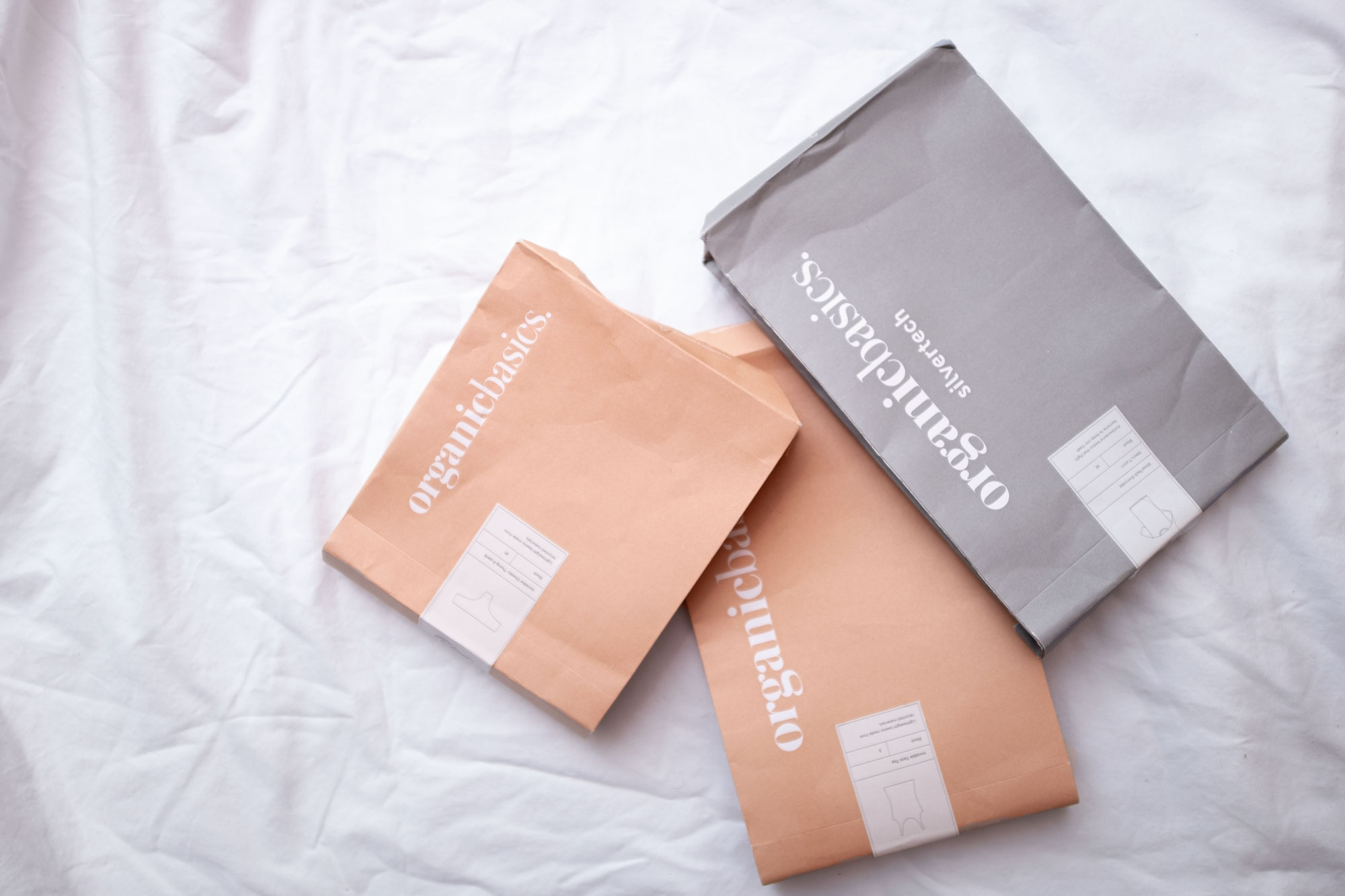 Organic Basics Packaging on a white bed sheet