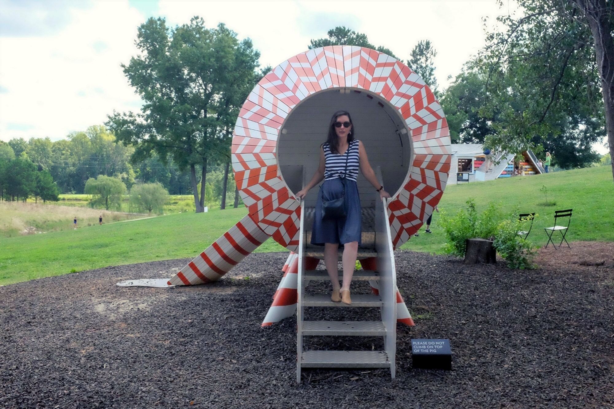 Alyssa standing in a wooden pig-shaped sculpture in Raleigh