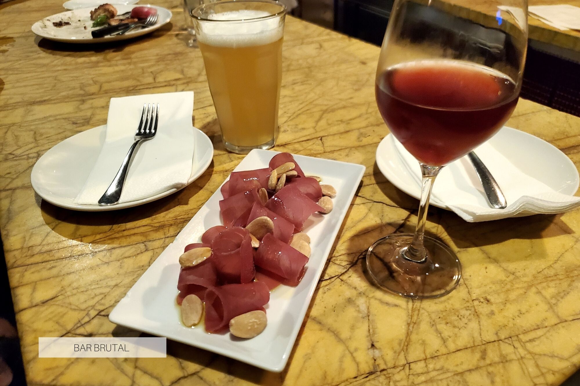 Dried tuna, a a glass of wine, and a beer at Bar Brutal