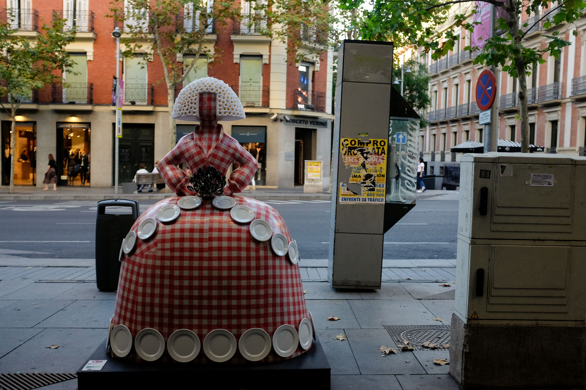A Menina statue - she is dressed as a table, with a gingham dress and plates decorating