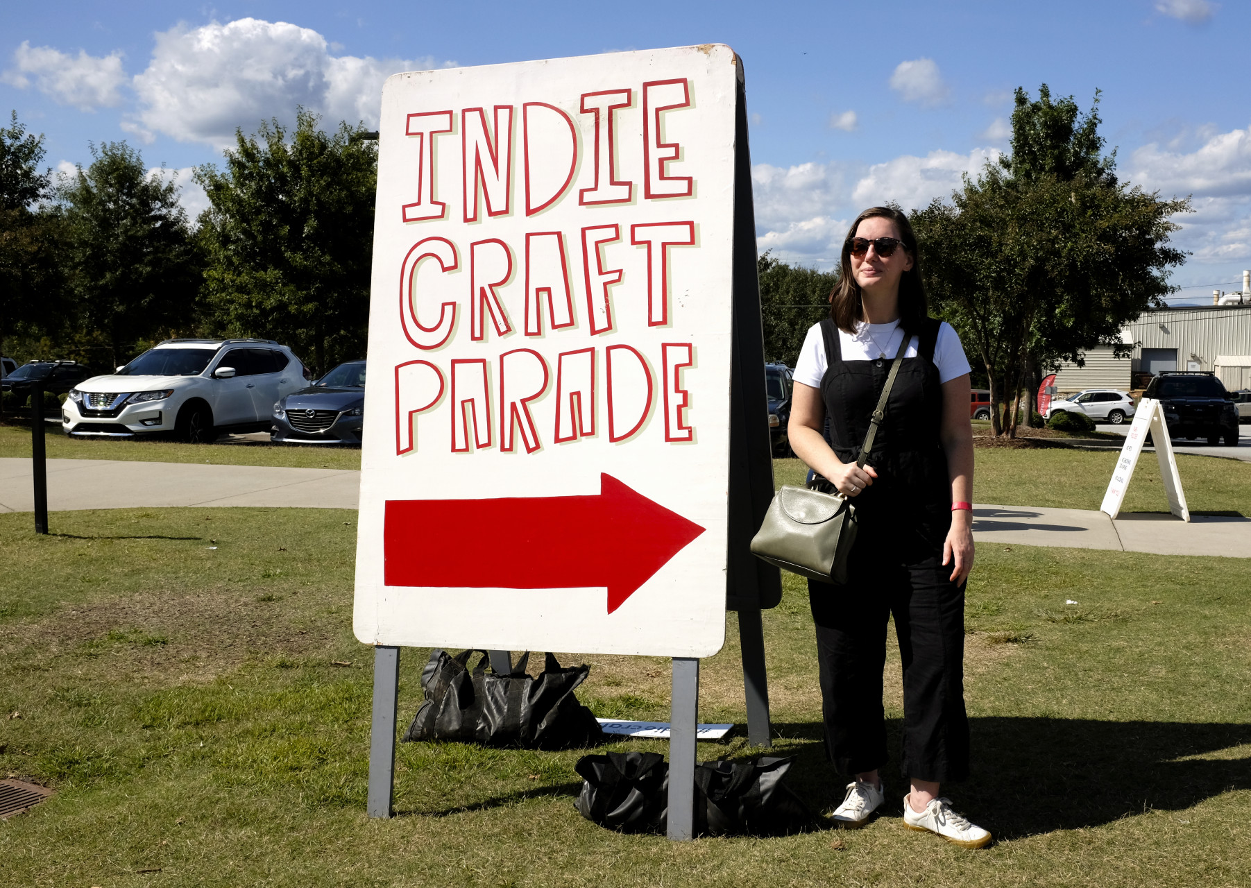 Krystal is standing to the right of a large sign that reads Indie Craft Parade
