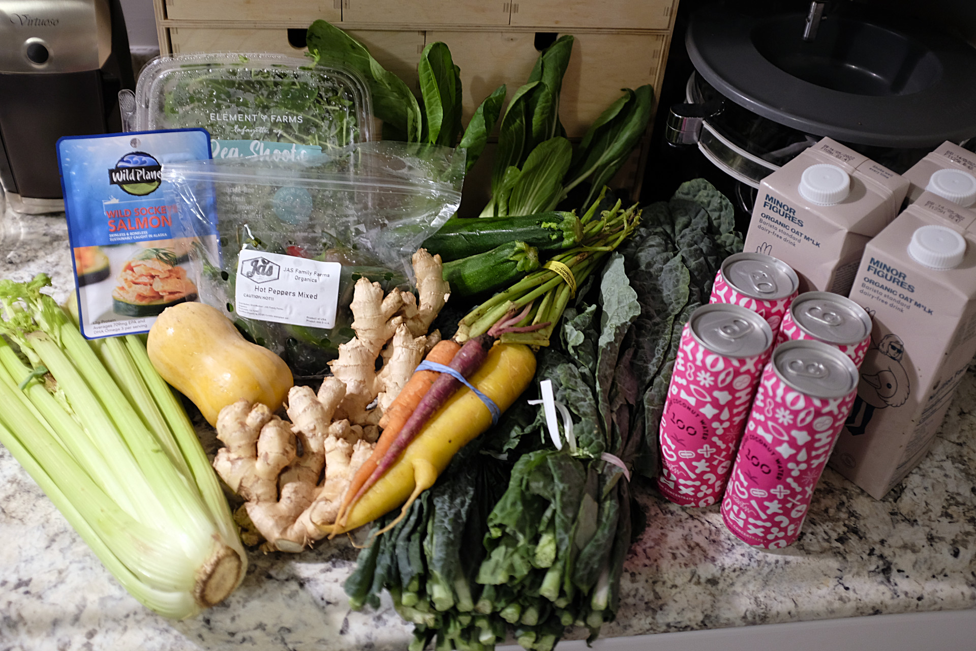 A pile of produce and groceries sits on a kitchen counter