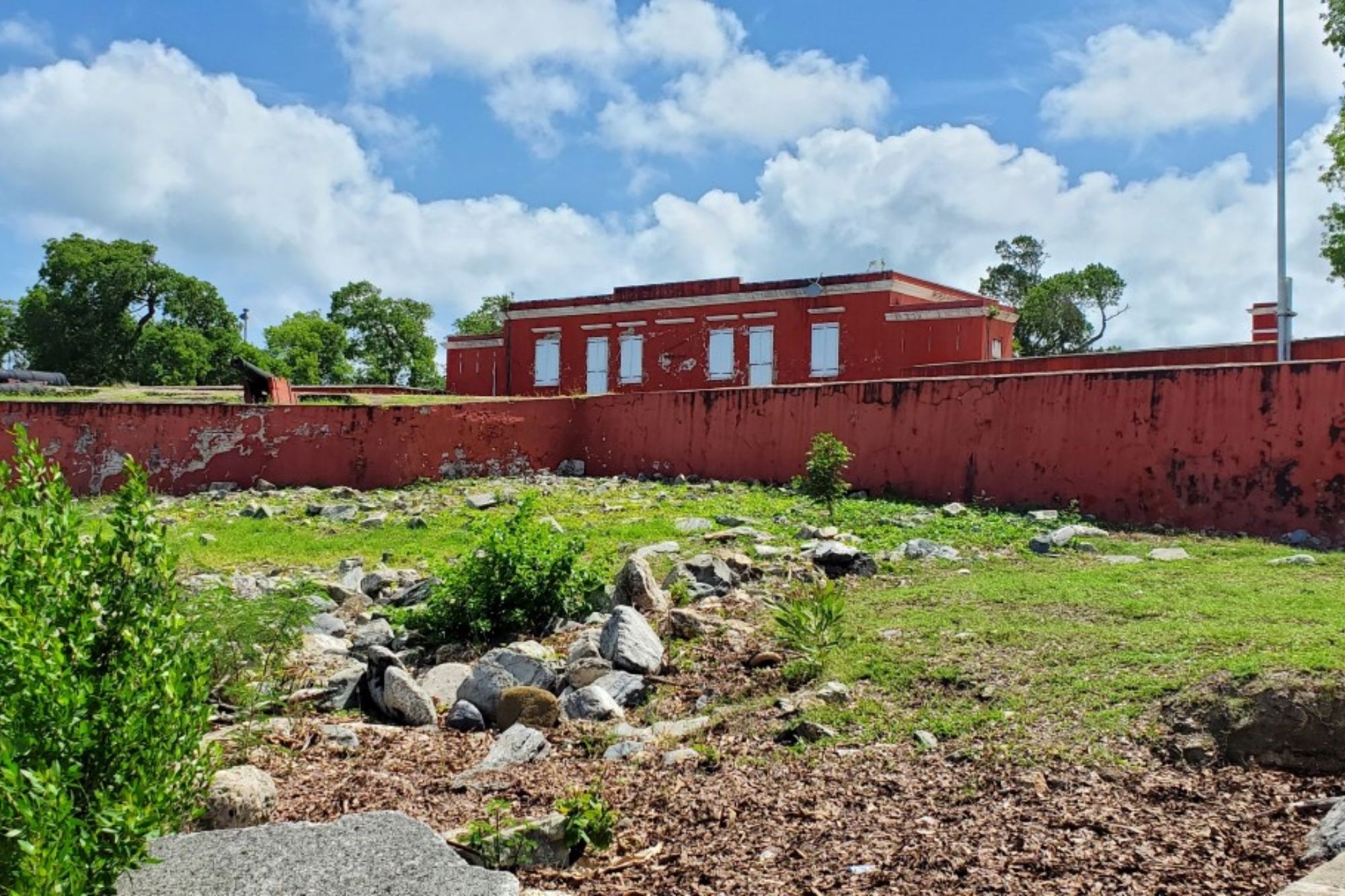 a red fort with rocks and grass in the foreground