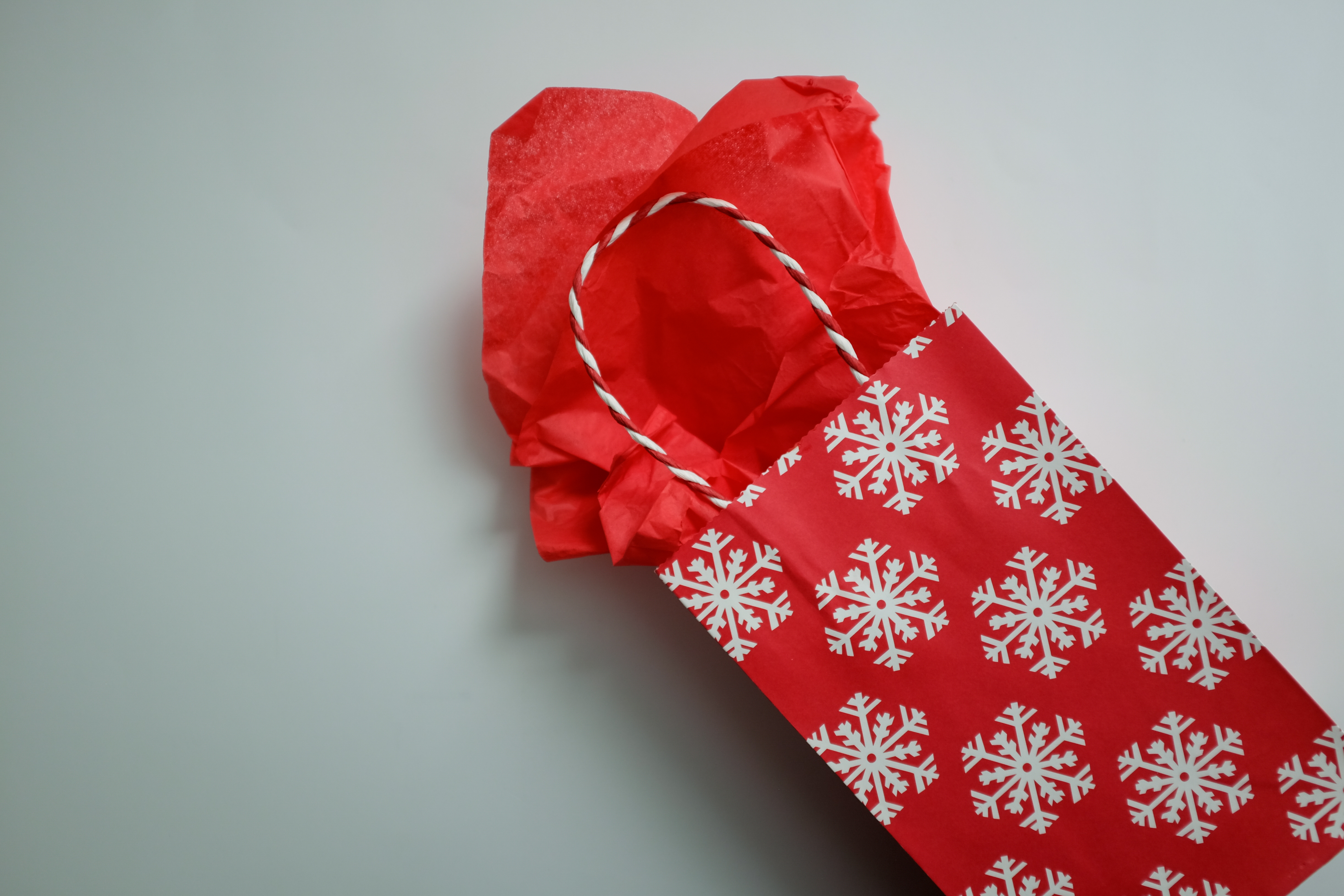 A red gift bag with white snowflakes