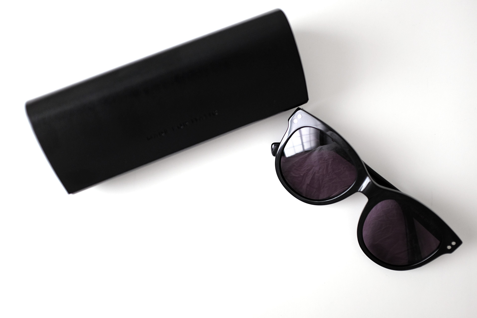 A sunglass case and sunglasses on a white background. The case reads "MADE FOR ITALIC"