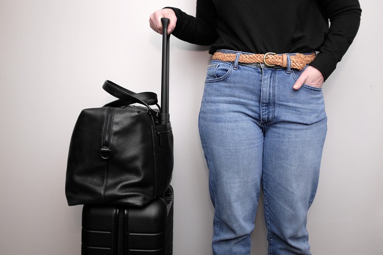 A close-up shot of Alyssa standing with the Away Everywhere Bag and Carry On