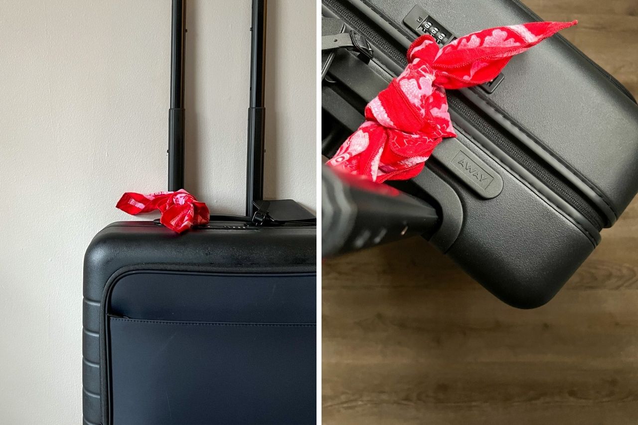 An Away suitcase with a red bandana tied on the handle