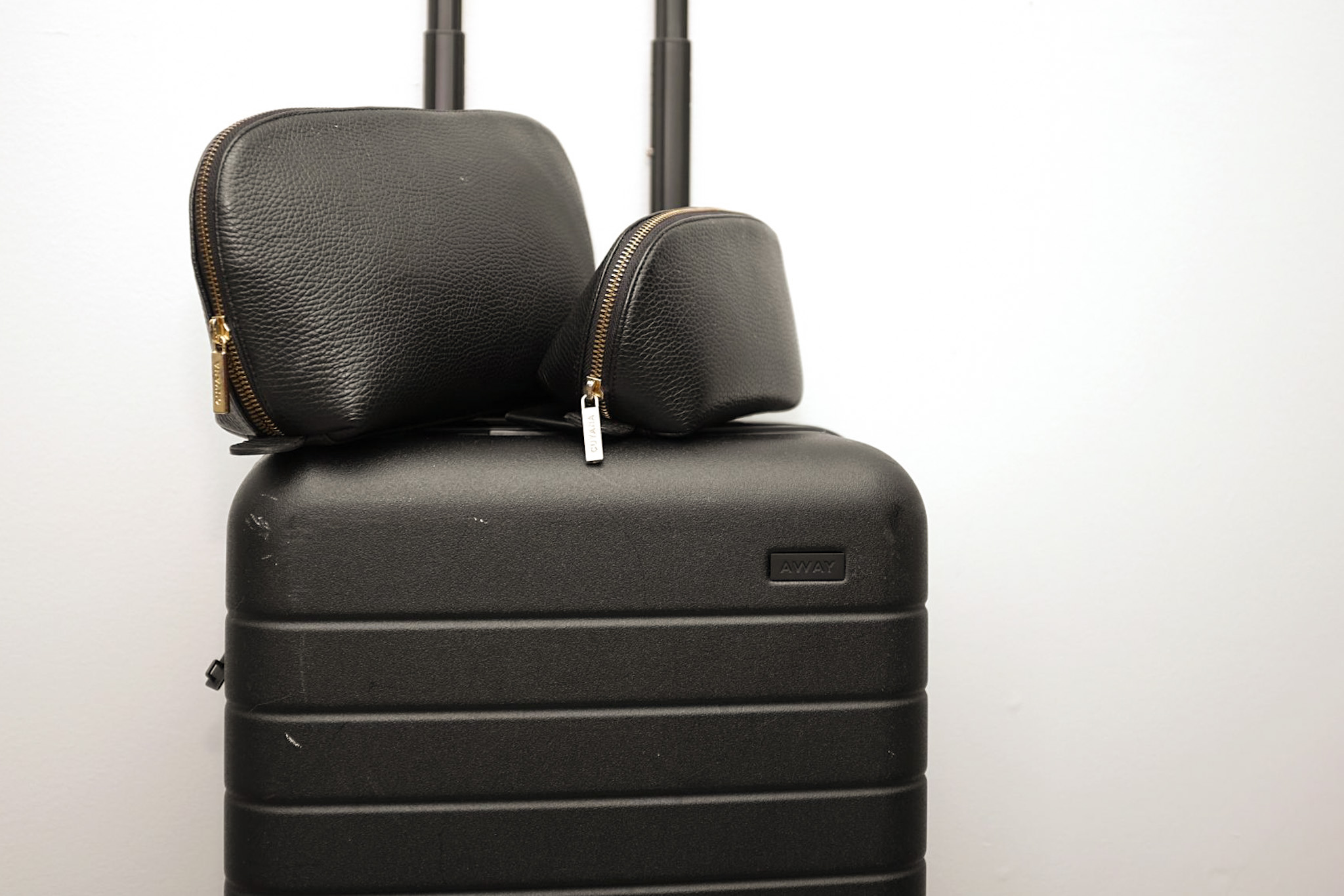 The Leather Travel Set sits on top of an Away suitcase
