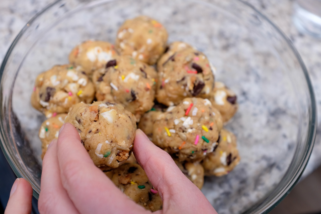 Large balls of cookie dough studded with sprinkles, nuts, and chocolate chips