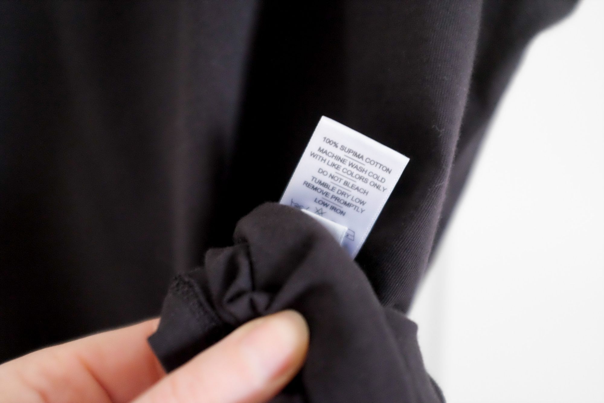 Close up of a fabric tag that reads 100% Supima Cotton