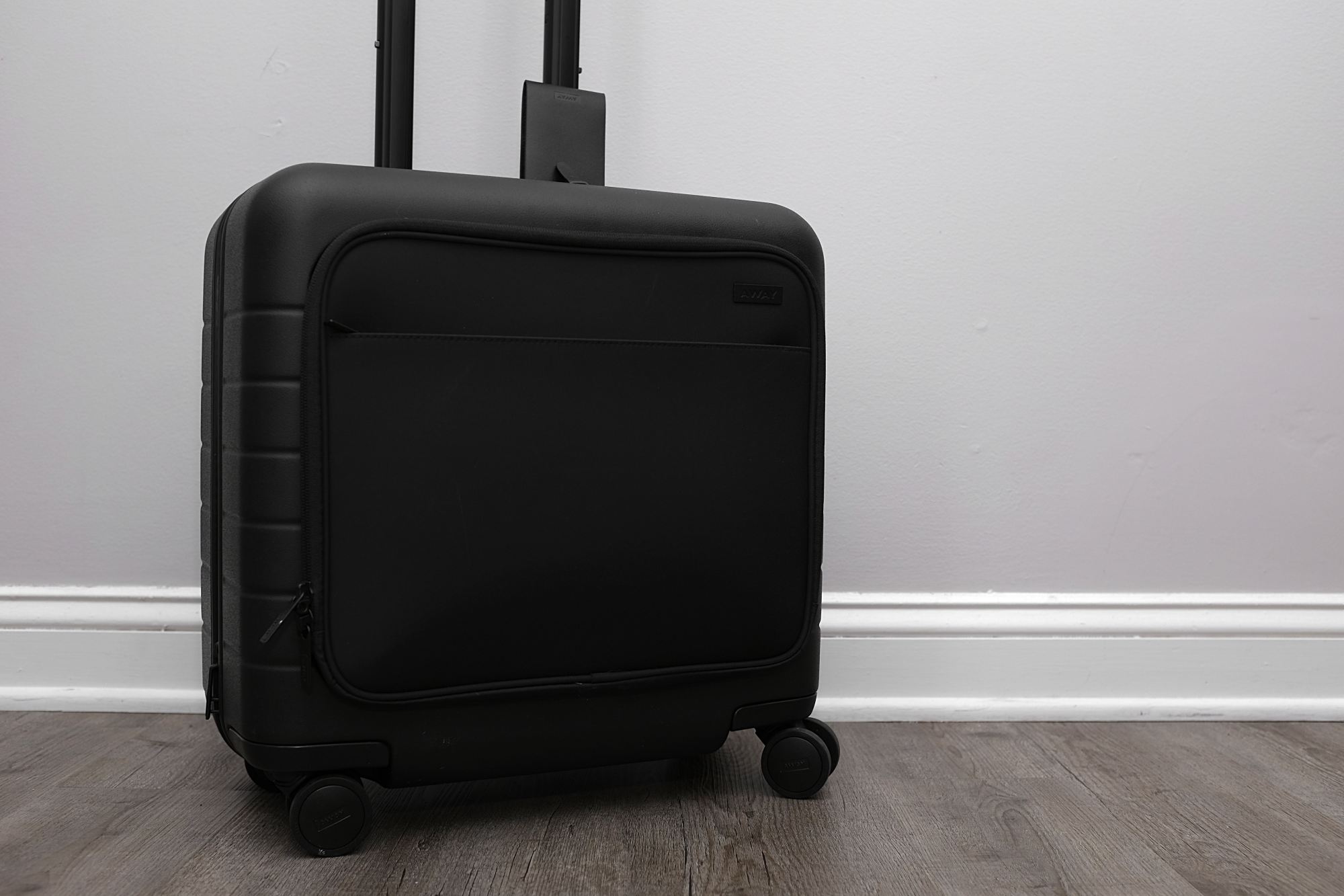 the Daily Carry On with Pocket on a wood floor in front of a grey wall