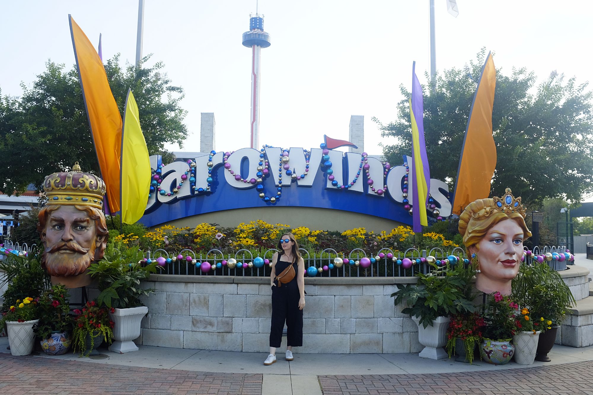 Alyssa stands in front of the Carowinds sign in a jumpsuit and sneakers