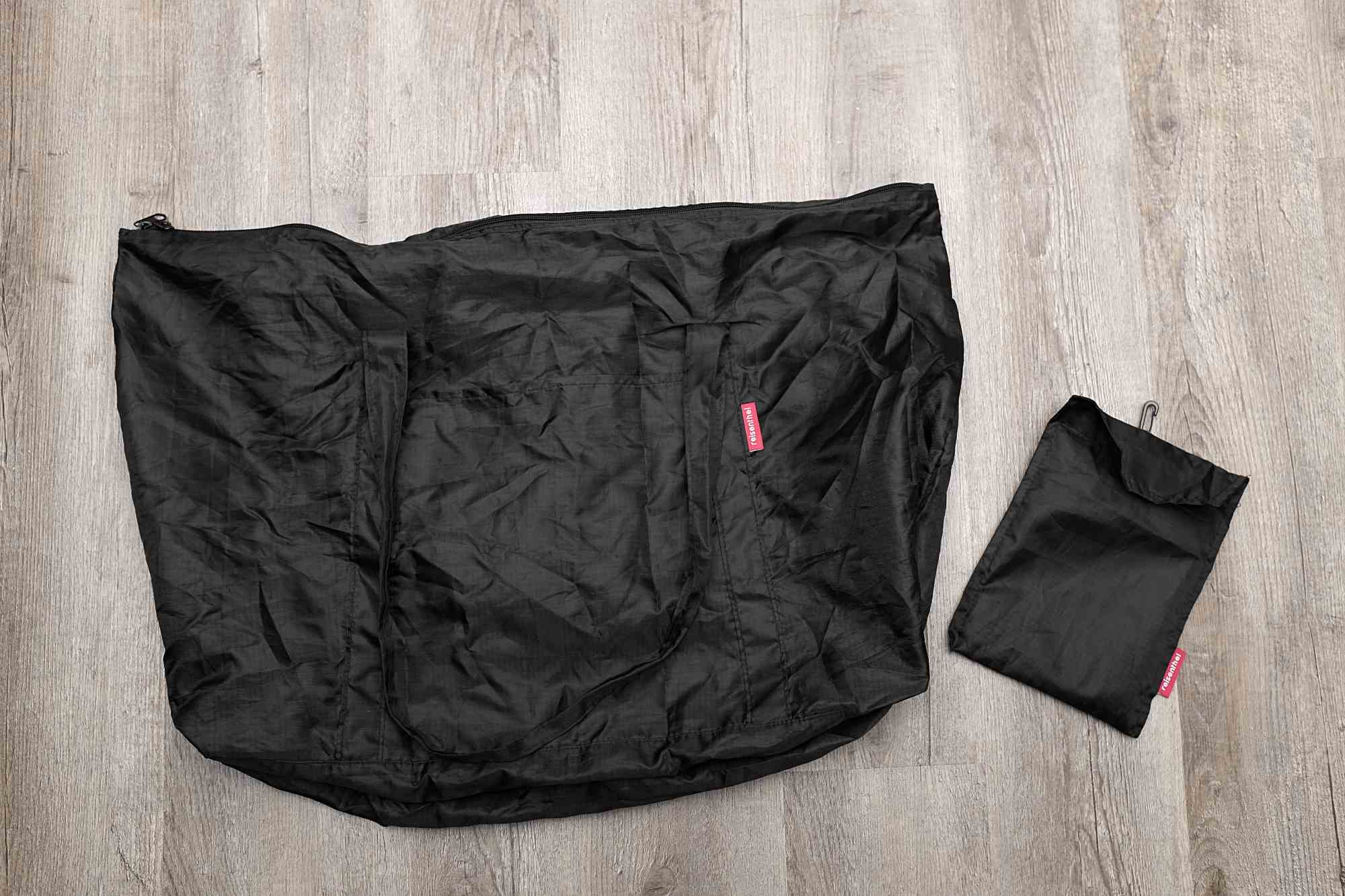 The tote lays flat on the floor next to the carry pouch
