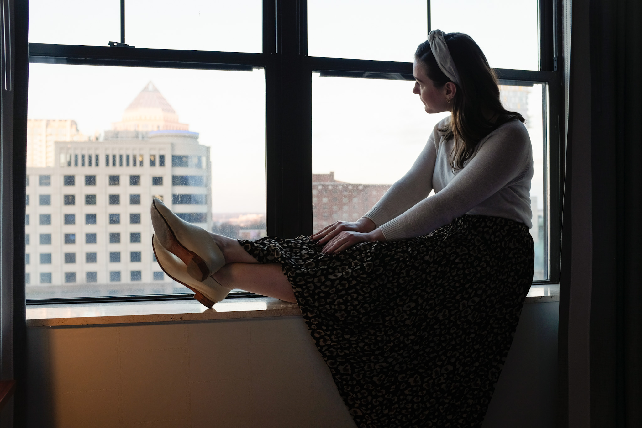 Alyssa looks out the window at The Dunhill Hotel in Uptown Charlotte