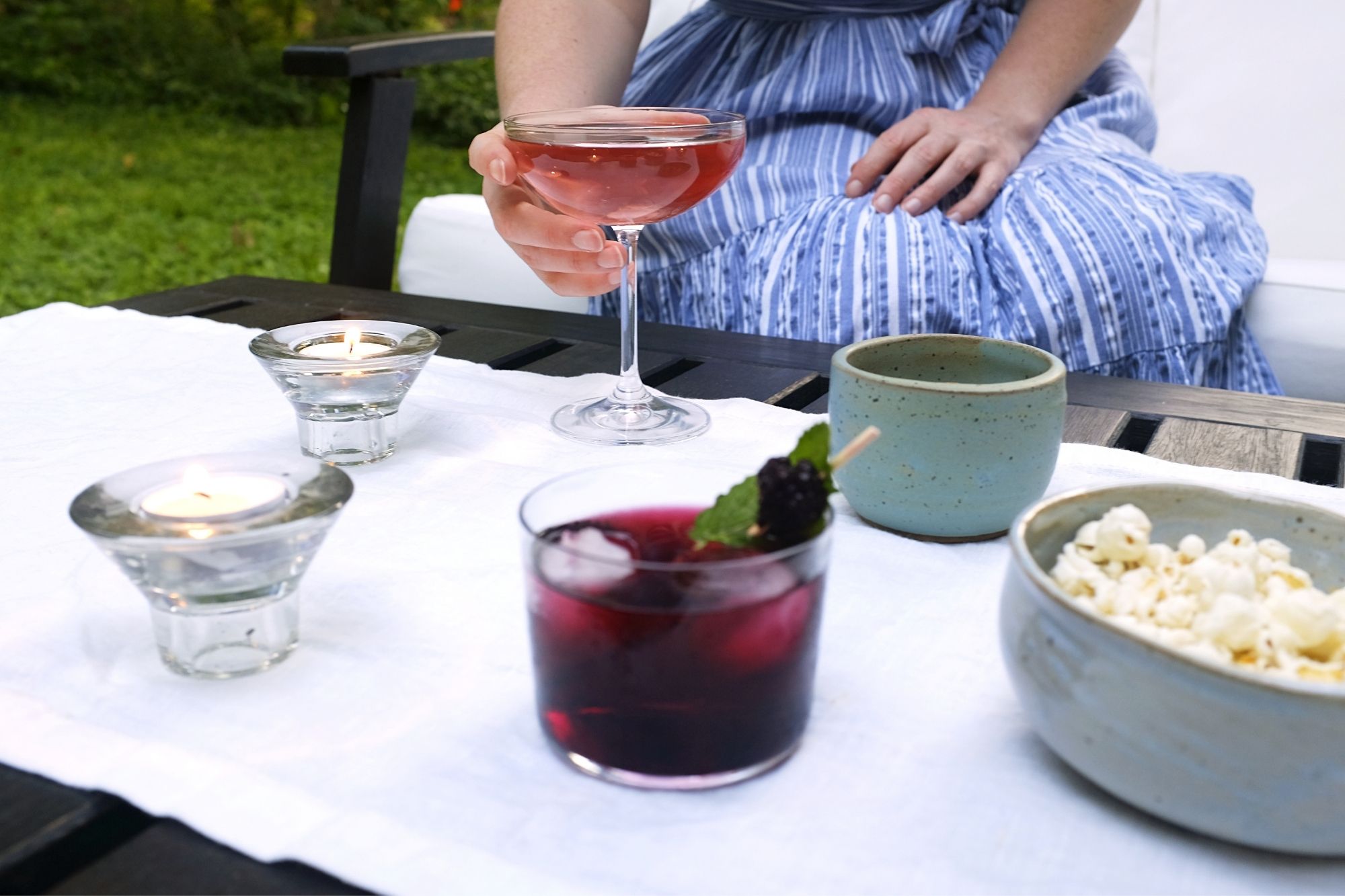 Alyssa grabs a prosecco cocktail from an outdoor table