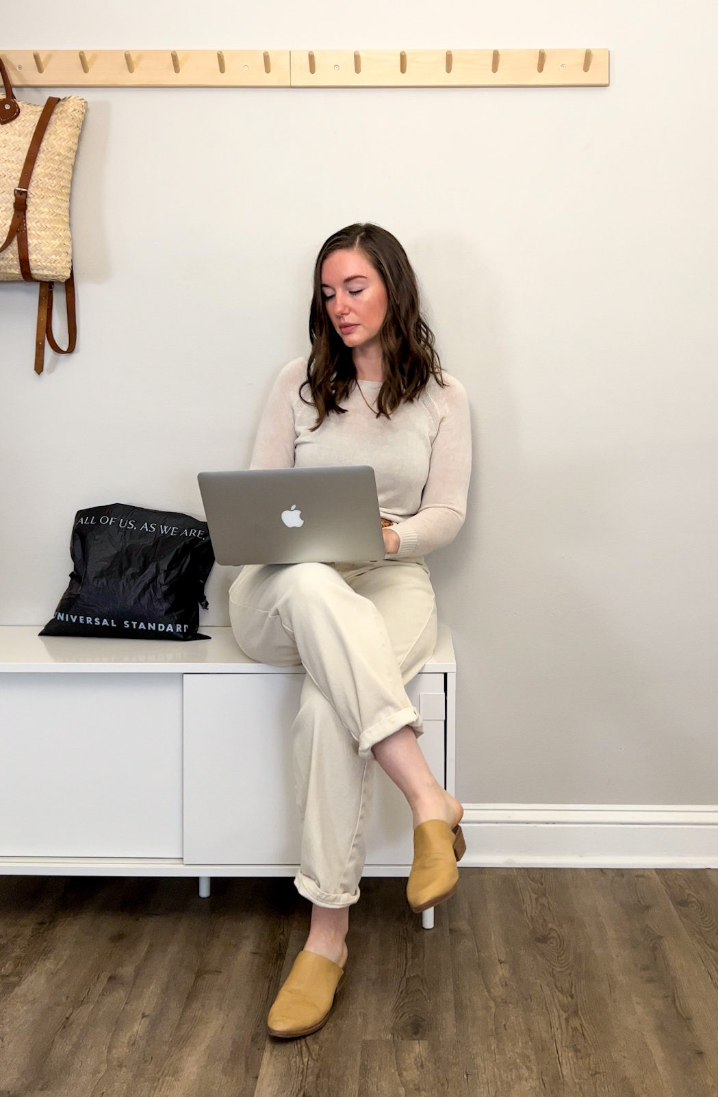 Alyssa sits with her laptop next to a bag from Universal Standard