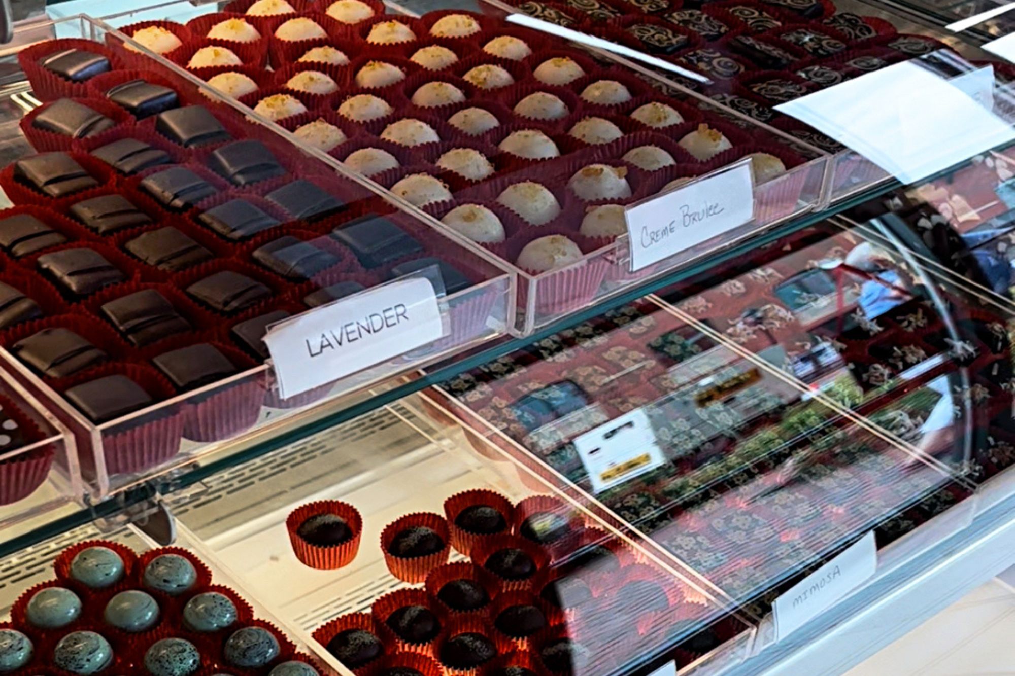rows of chocolate bonbons behind glass