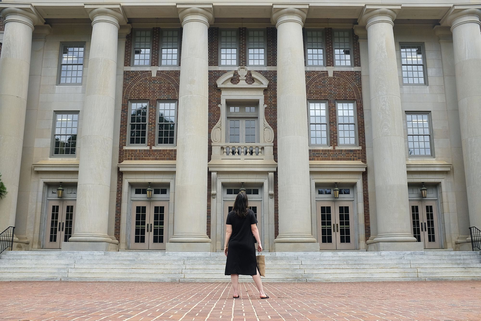 Alyssa stands in front of columns on a building on campus