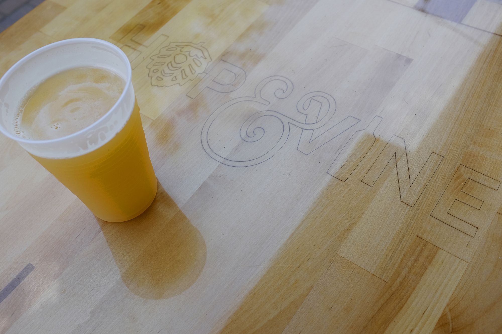 A beer on a table that reads "Hop & Vine"