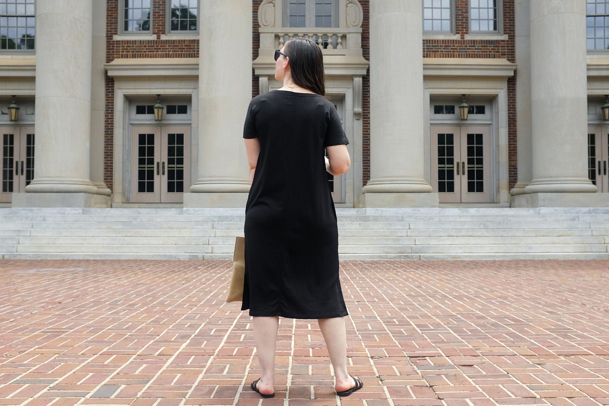 Alyssa stands and looks at a building on campus at Davidson College