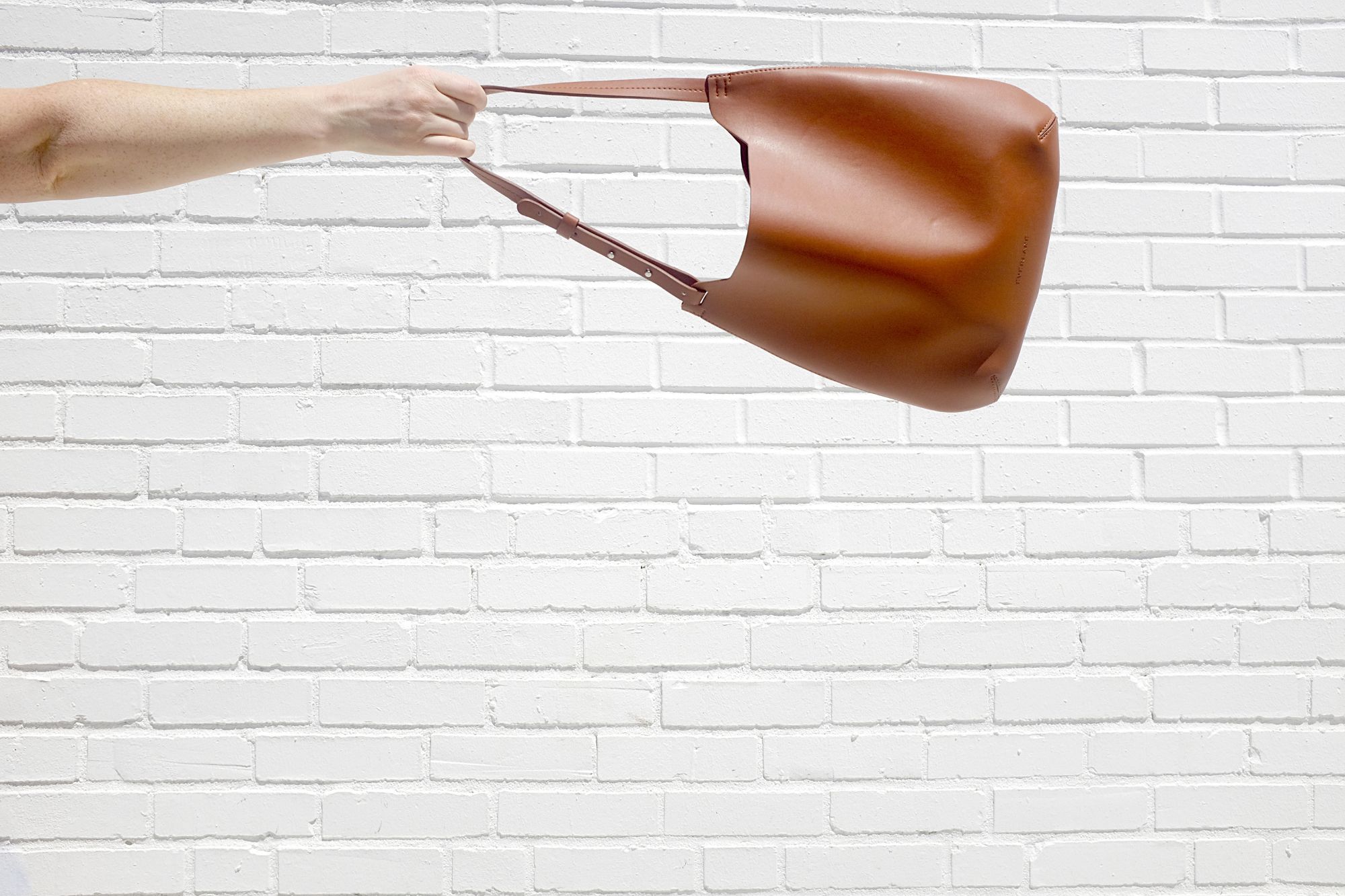 The Cactus Leather Hobo Bag is swung in the air