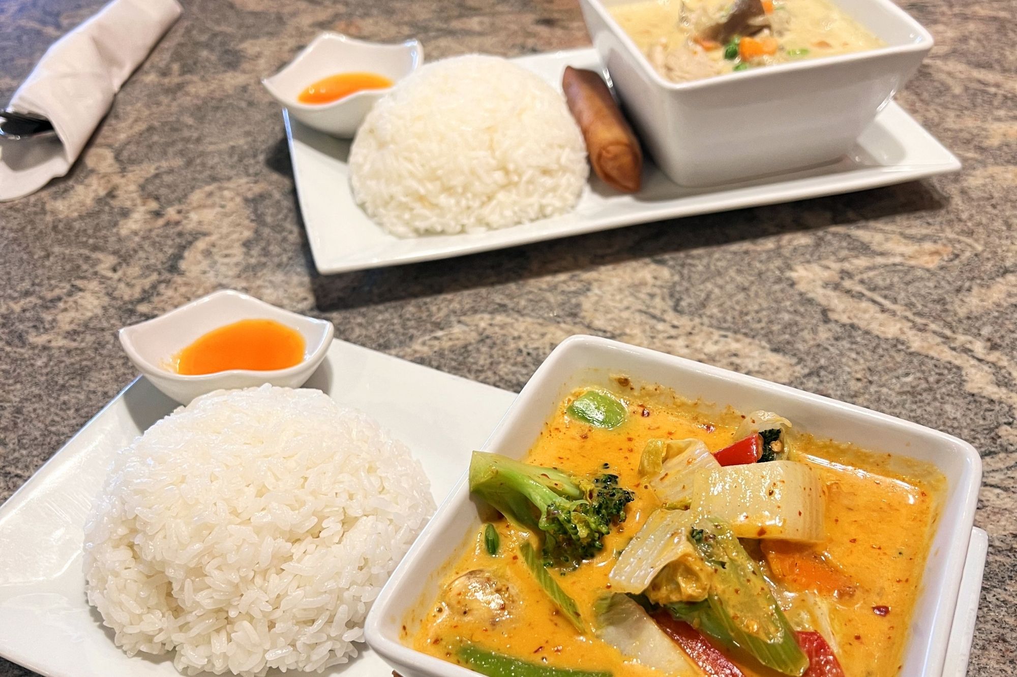 A panang curry with vegetables and a green curry with pork