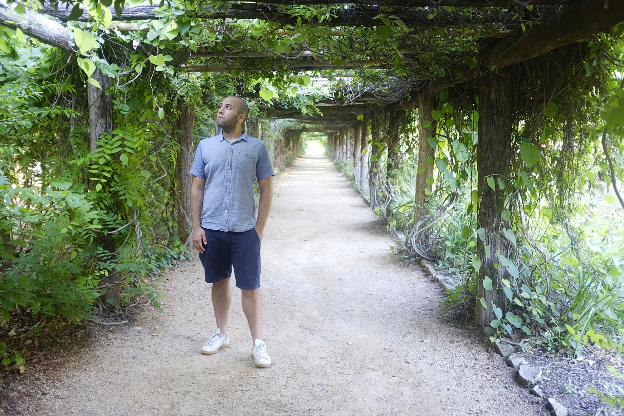 Michael stands under a canopy of vines in the Coker Arboretum