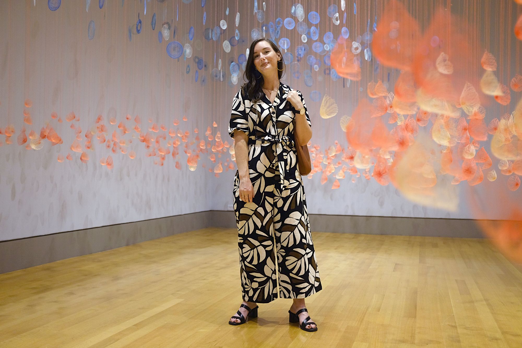 Alyssa stands in front of an exhibit at the COLA Museum of Art