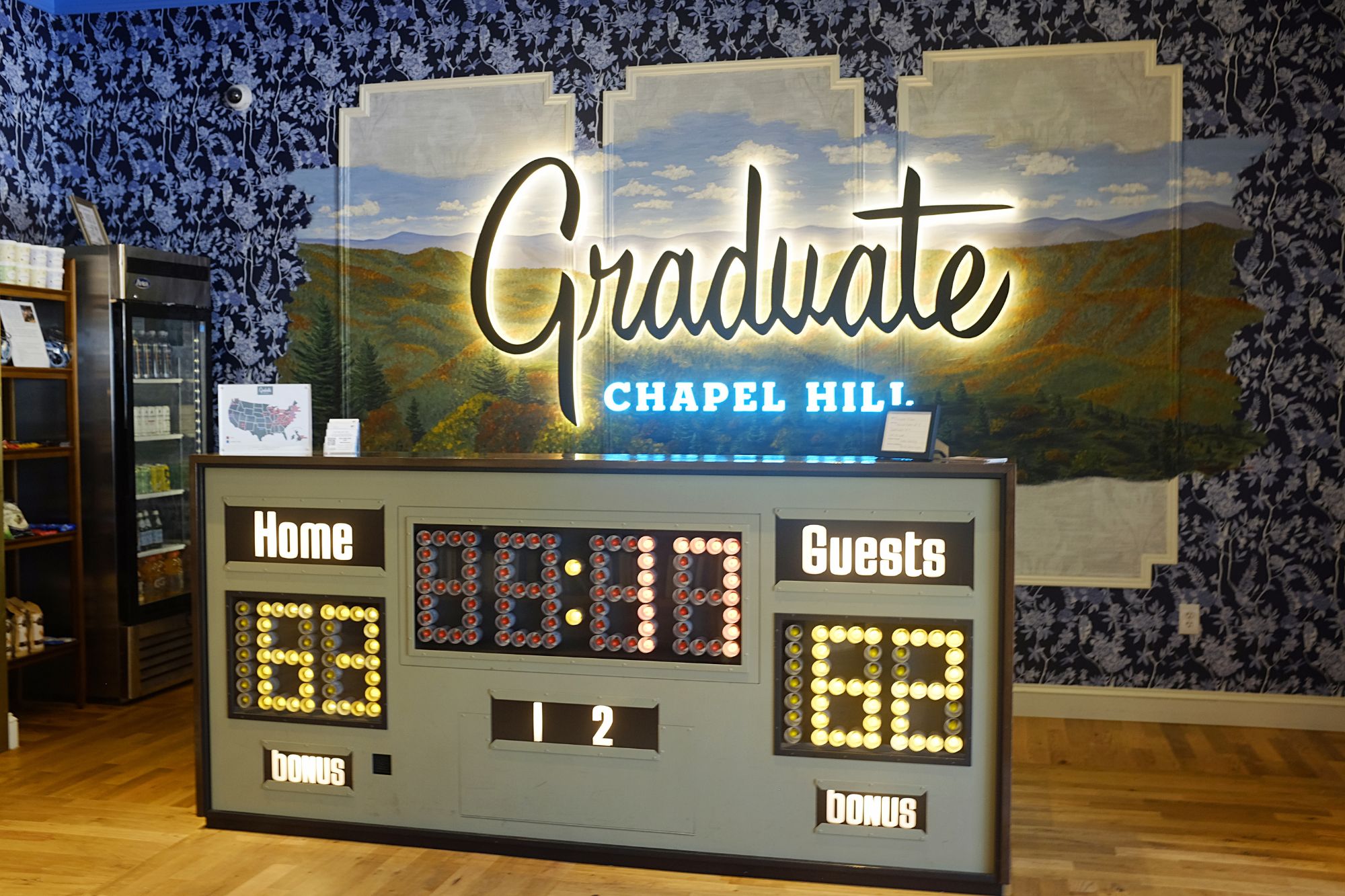 The check in desk at Graduate Chapel Hill features a basketball scoreboard
