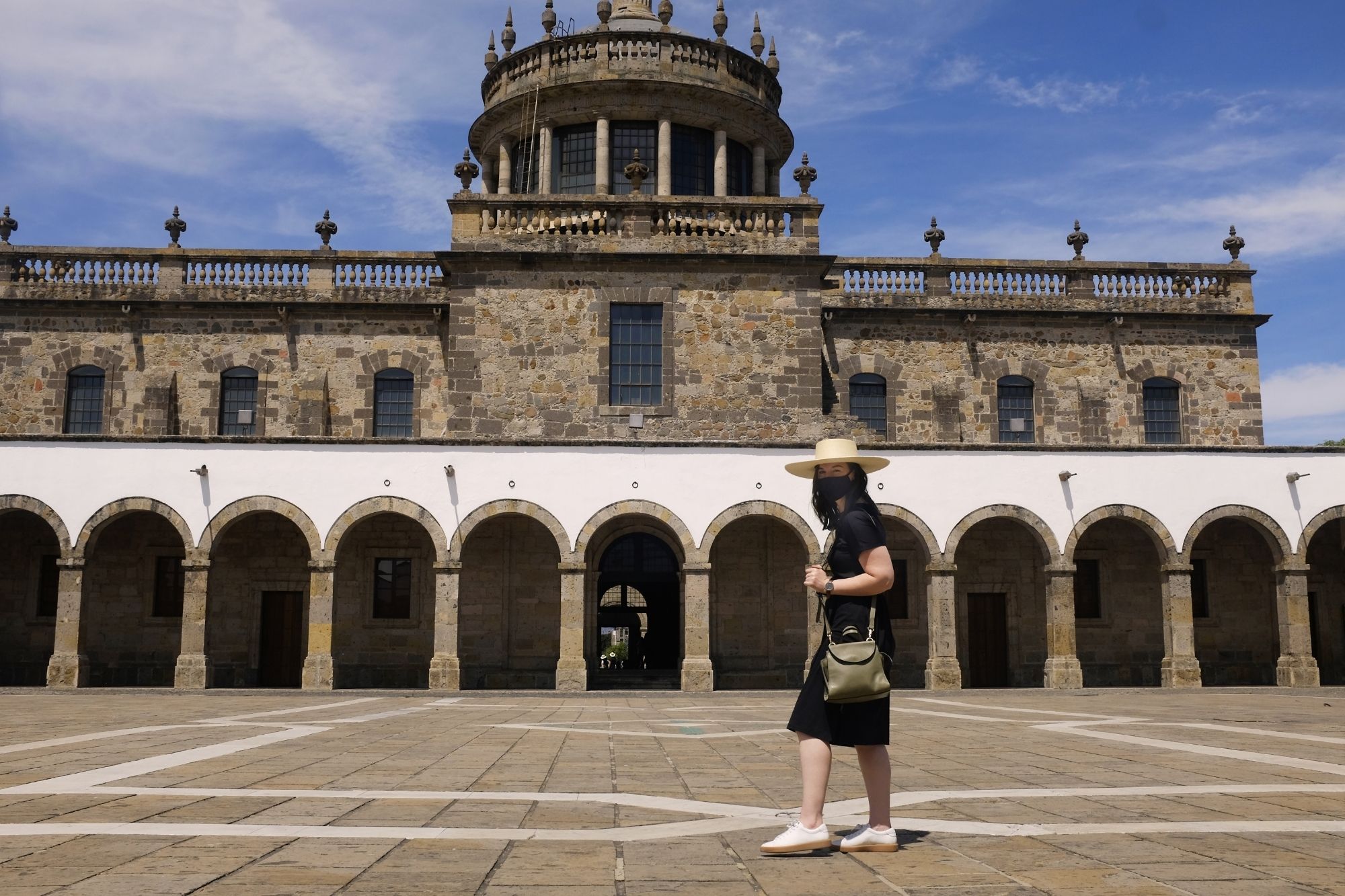 Alyssa stands in front of the Hospicio Cabanas in a black dress