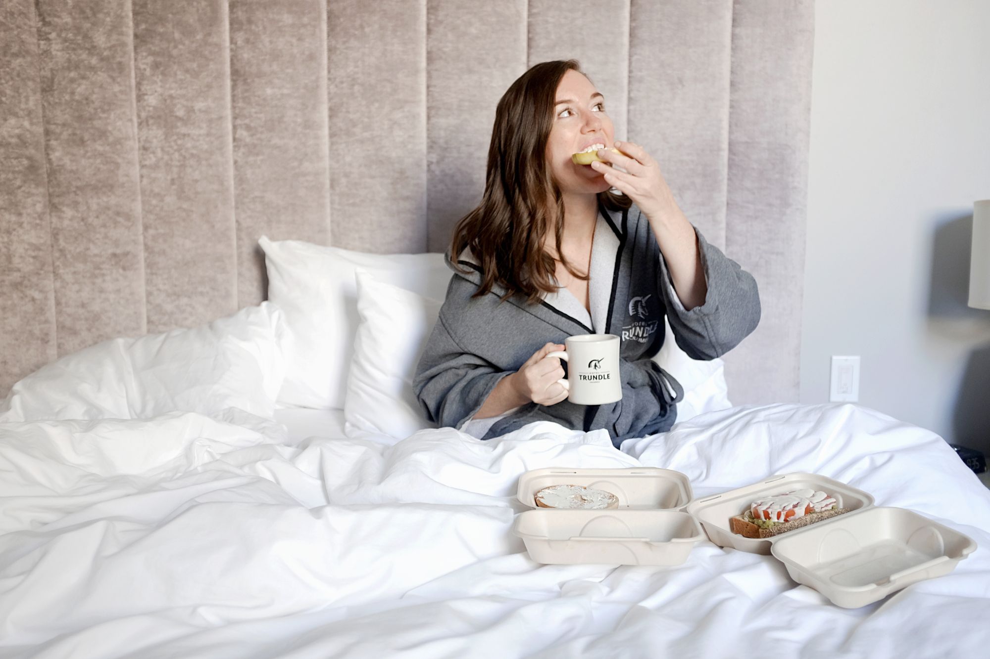 Alyssa eating a bagel in bed