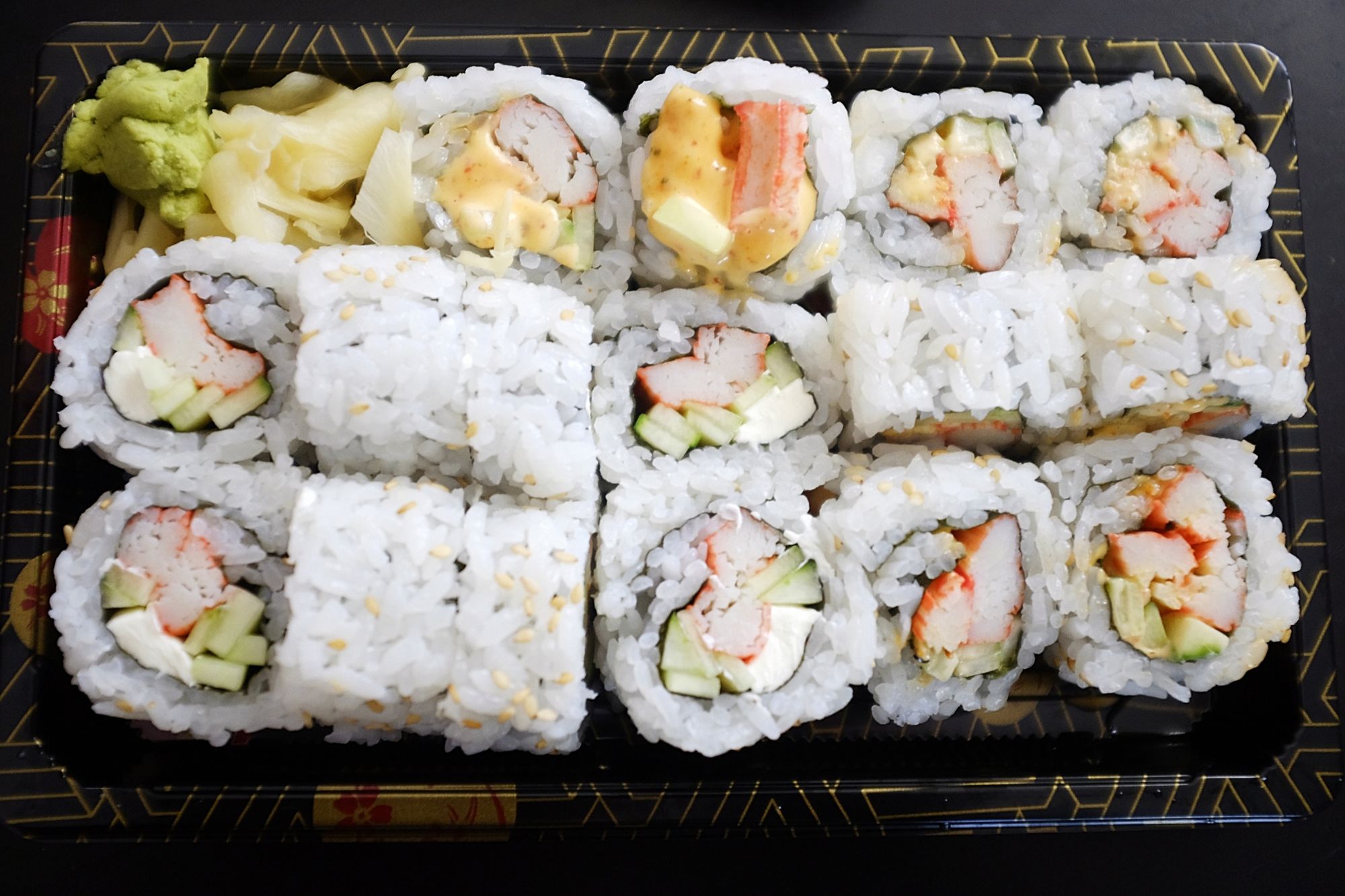 Twelve pieces of sushi in a takeout box
