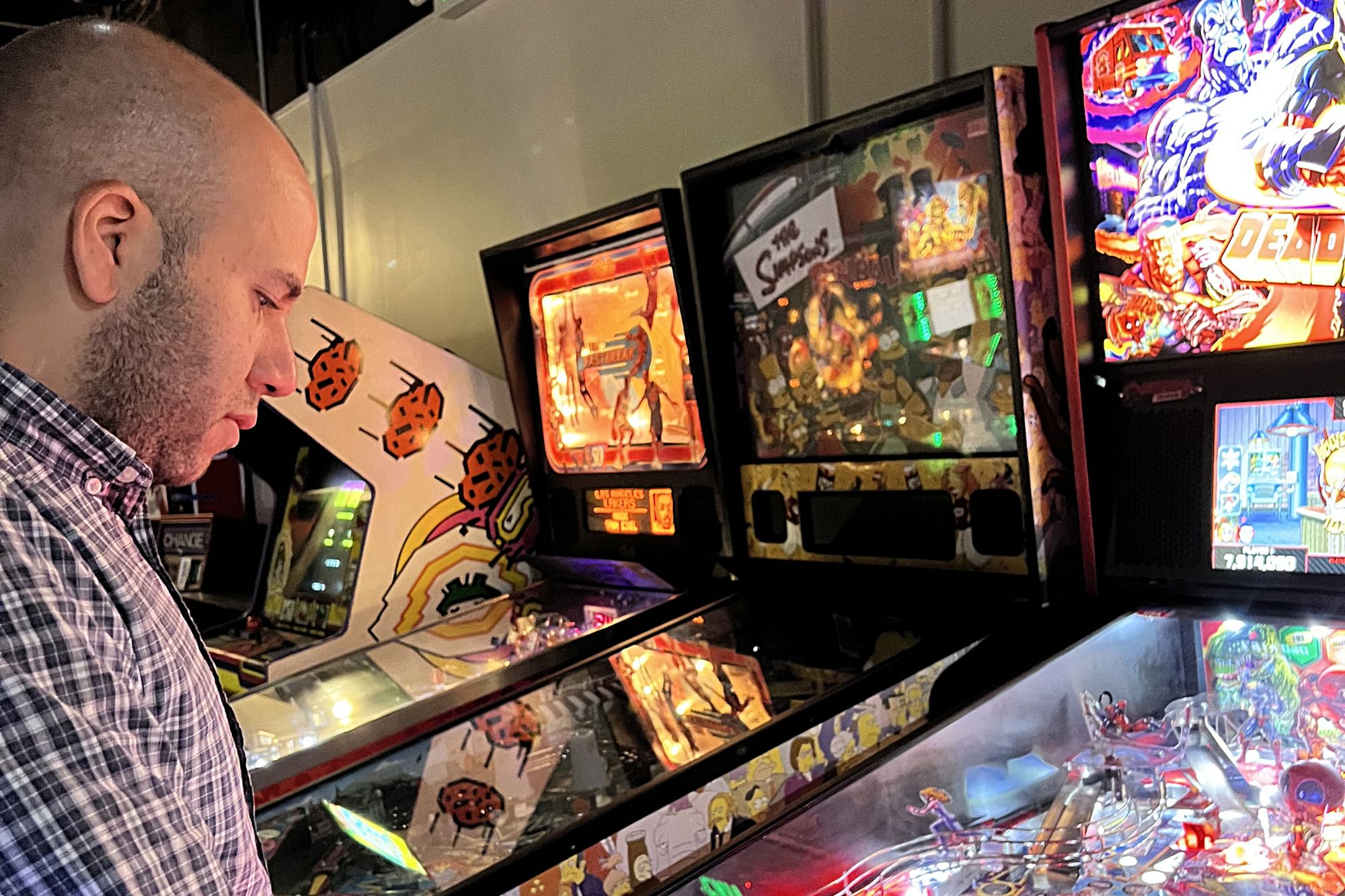 Michael playing a pinball machine at Transmission Arcade