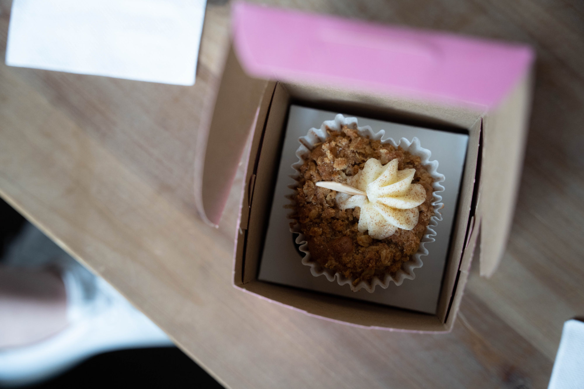 A sweet pink bakery box with a cupcake inside